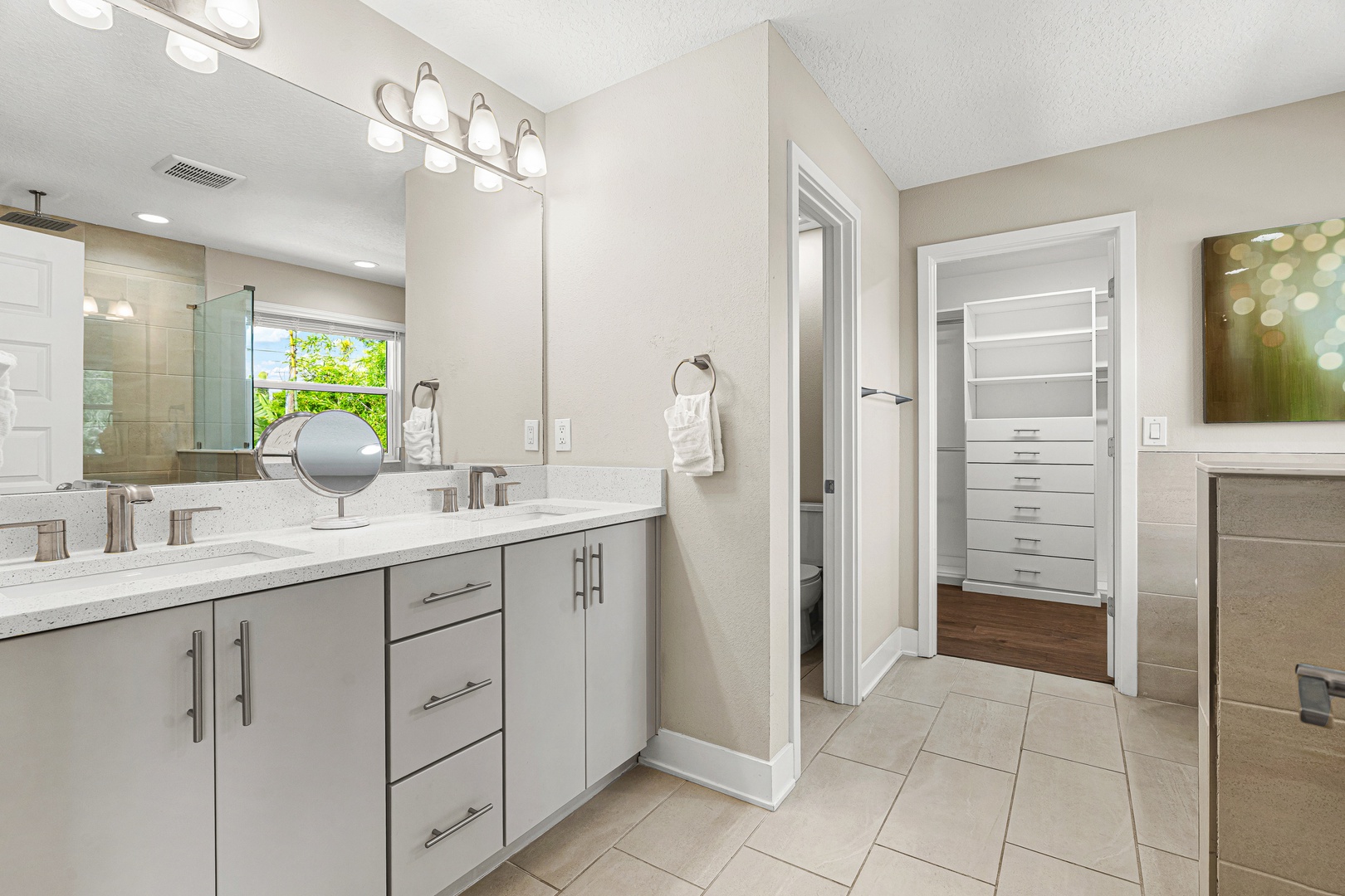 Freshen up in your beautifully lit ensuite with dual vanities, a spa-like shower, and direct access to an organized walk-in closet.