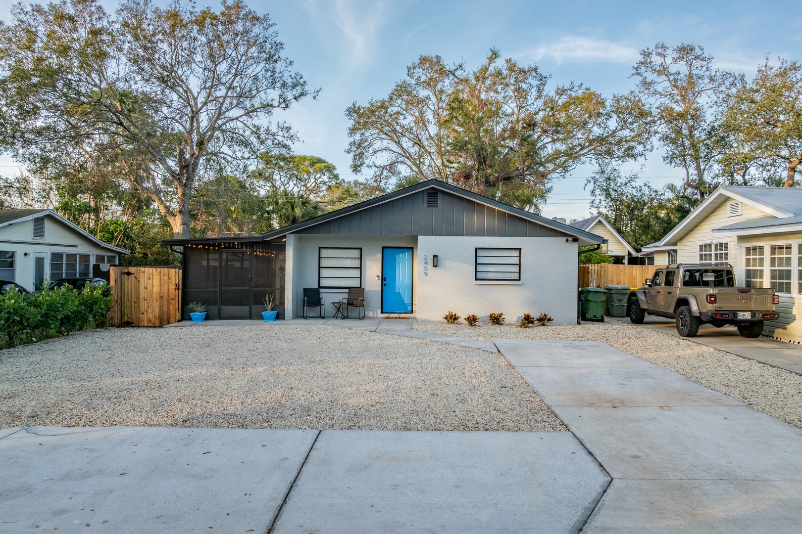 Modern vacation home with bright blue door and private parking in peaceful residential neighborhood.