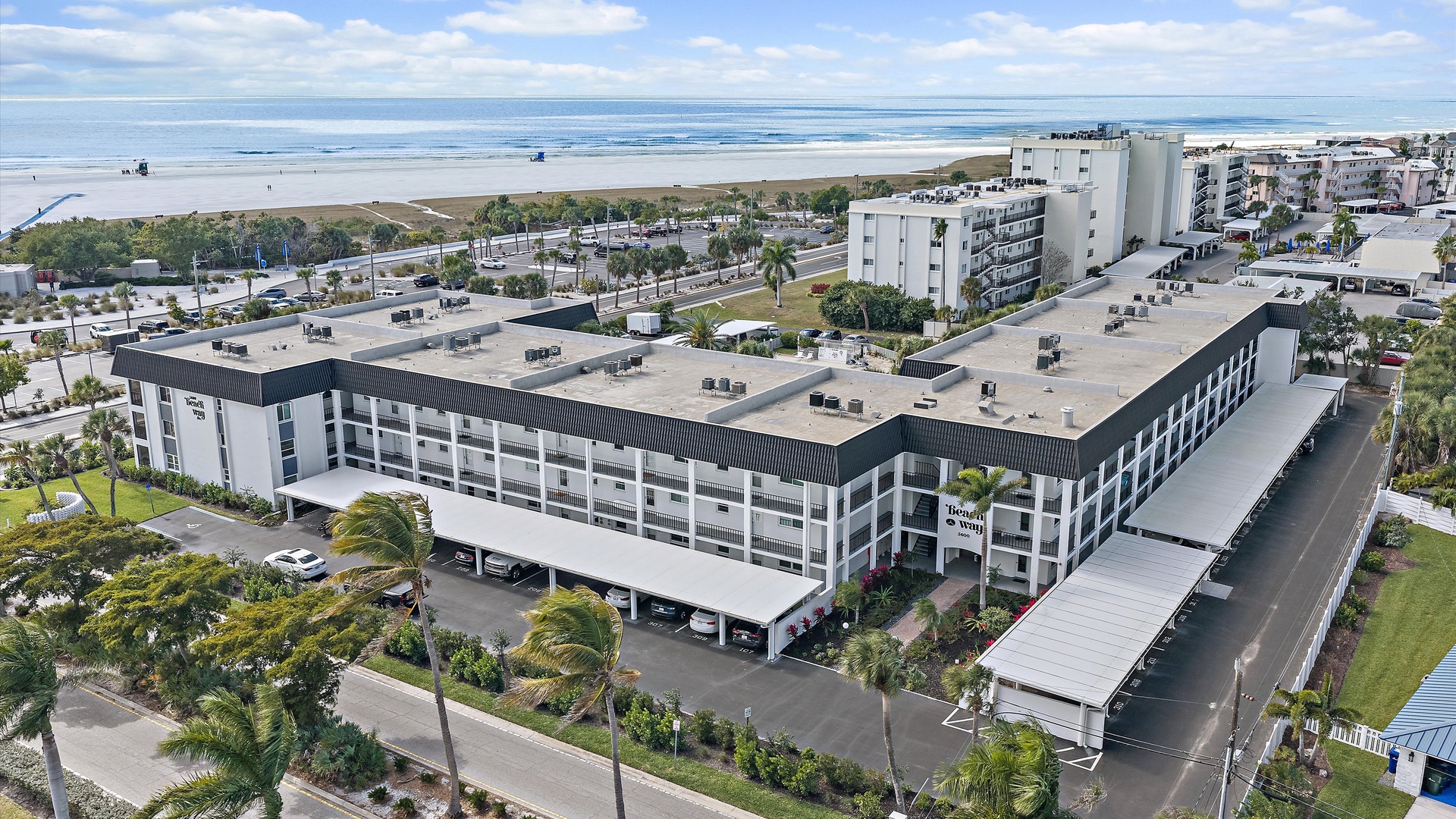 Modern beachfront hotel positioned steps from pristine sandy shores and rolling ocean waves in a vibrant coastal community.