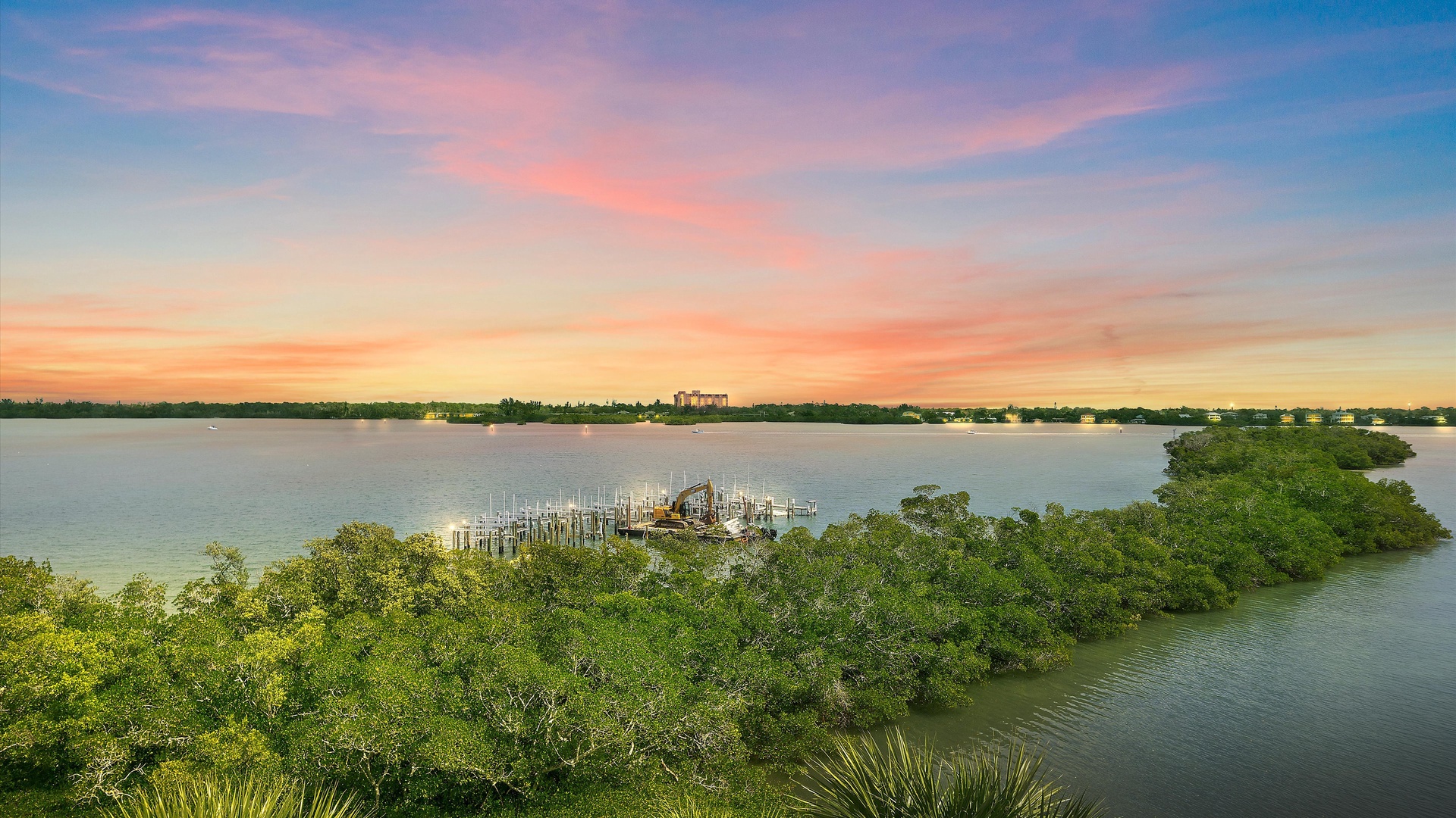 Stunning waterfront sunset paints the sky in brilliant colors above this peaceful lakeside location with private dock access.