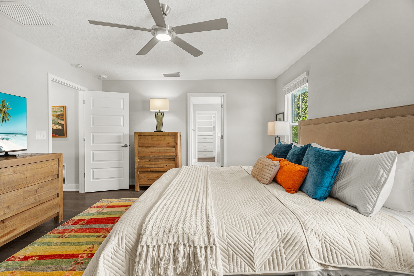 Unwind in the primary king bedroom with hotel-style linens, ensuite bathroom and soaking tub, plush towels, and Smart TV.