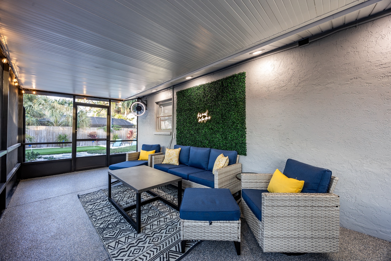 Relax in your stylish covered patio with comfortable seating, surrounded by lush garden views and modern design touches.