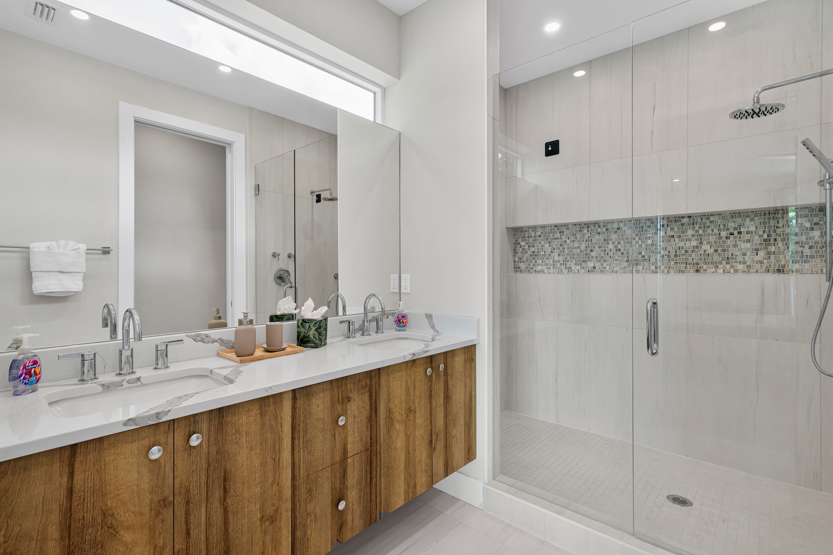 Step into your spa-like bathroom featuring a sleek double vanity, rainfall shower, and modern finishes that blend warmth with elegance.