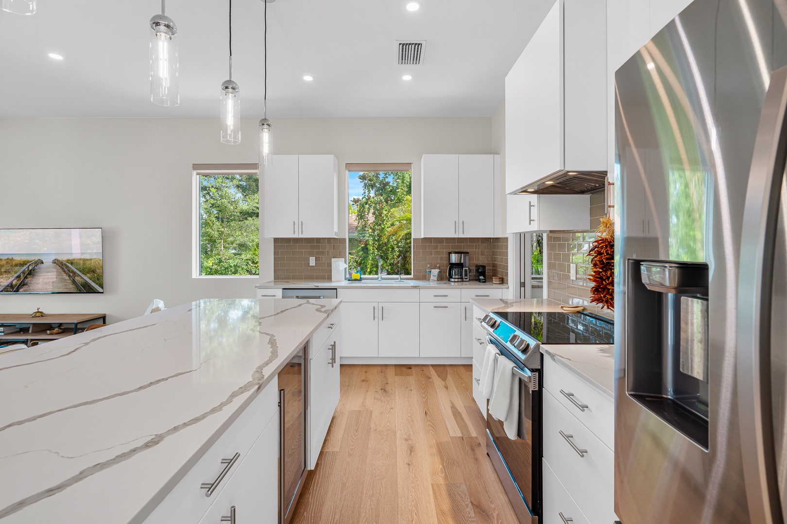 Your gourmet kitchen awaits with gleaming countertops, modern appliances, and sunlight streaming through windows. Prepare meals with ease in this bright, fully-equipped space featuring sleek cabinetry and all the conveniences you need.