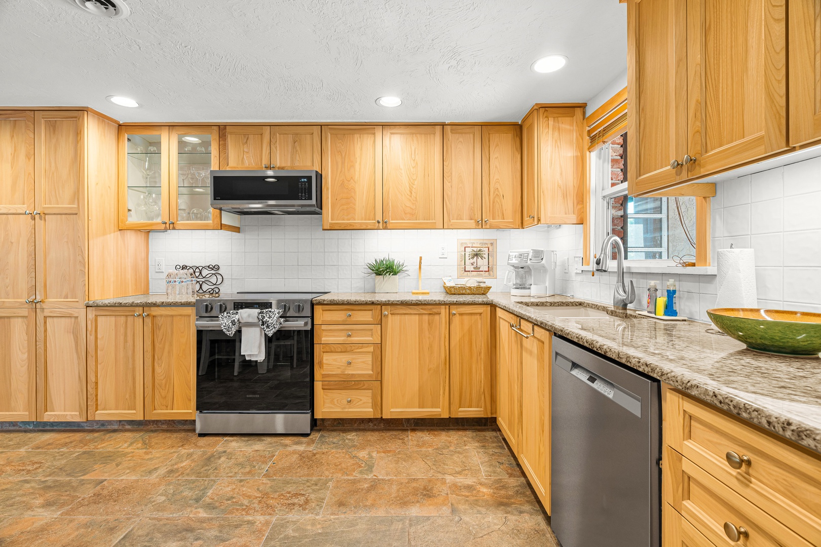 Your fully equipped kitchen features warm wood cabinetry, granite countertops, and modern stainless appliances—perfect for preparing meals at your own pace during your stay.