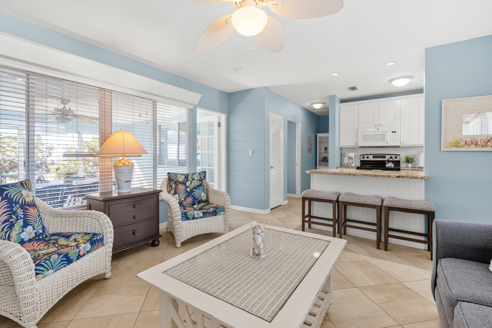 Cozy seating, patio access, and beach views from the main living space and kitchen island seating.