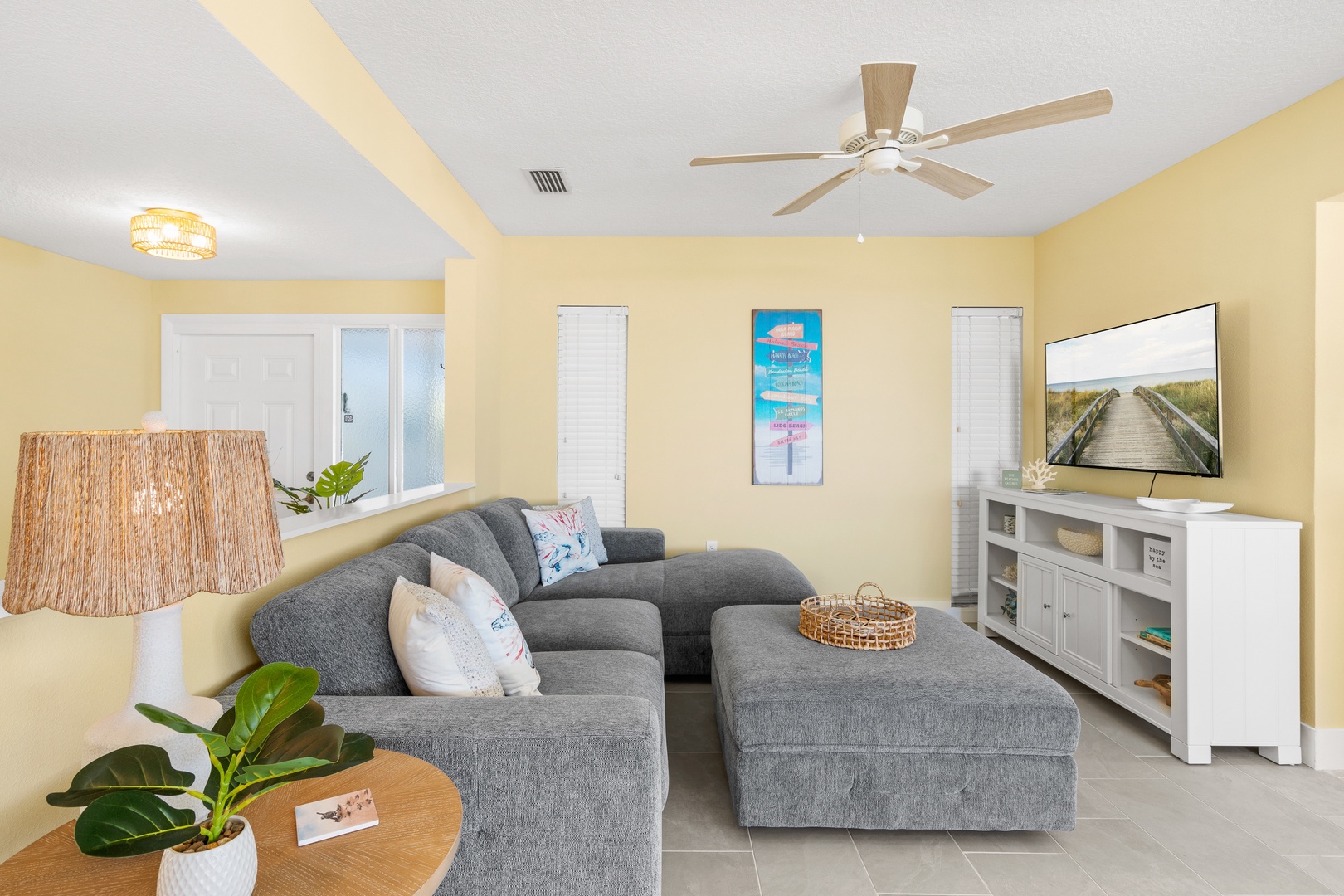 Sink into plush gray sectional seating while warm coastal breezes from your ceiling fan create the perfect atmosphere for relaxing evenings.