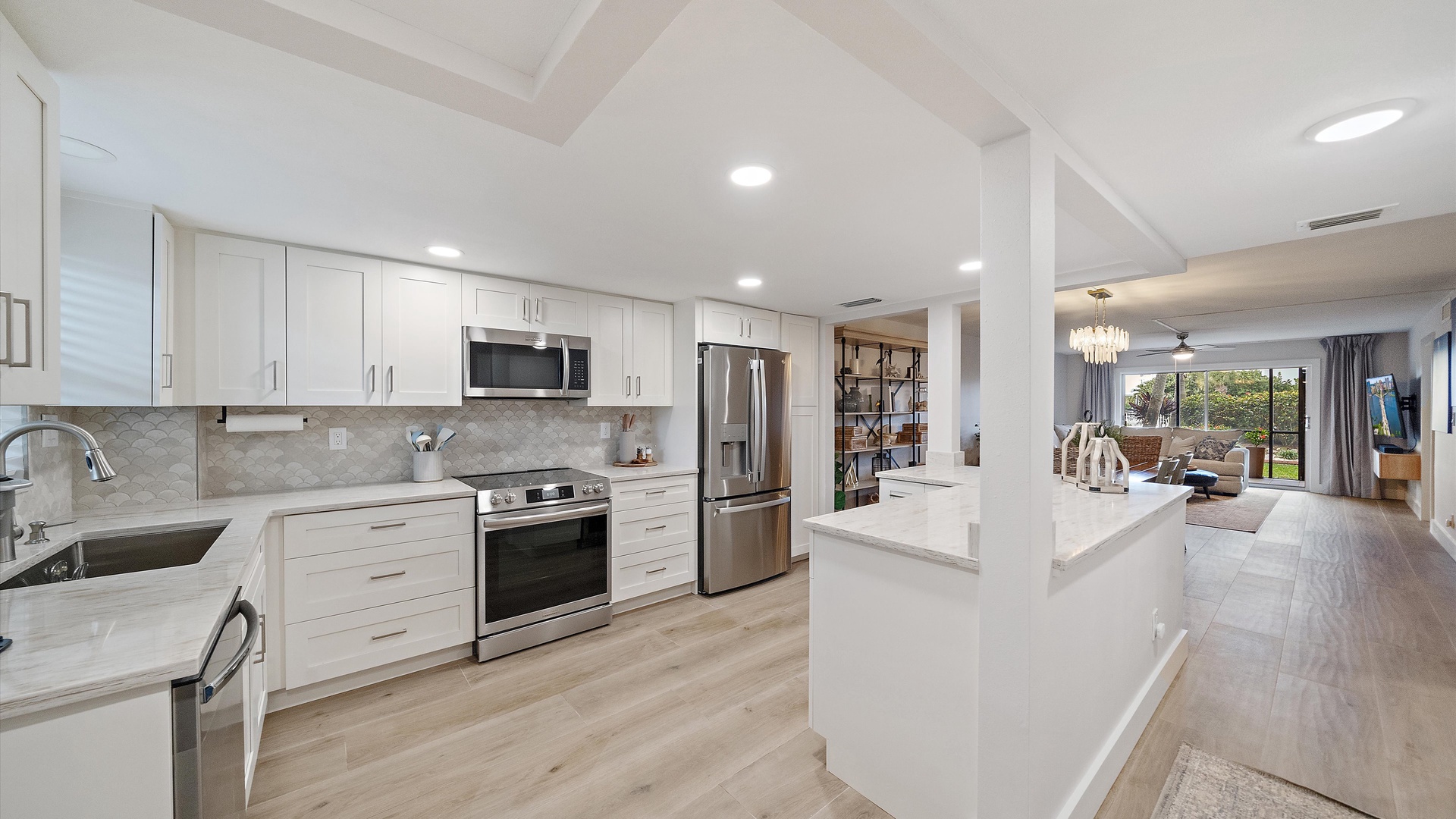Your sleek open kitchen flows seamlessly into the living space, featuring pristine white countertops and modern appliances perfect for cooking together.