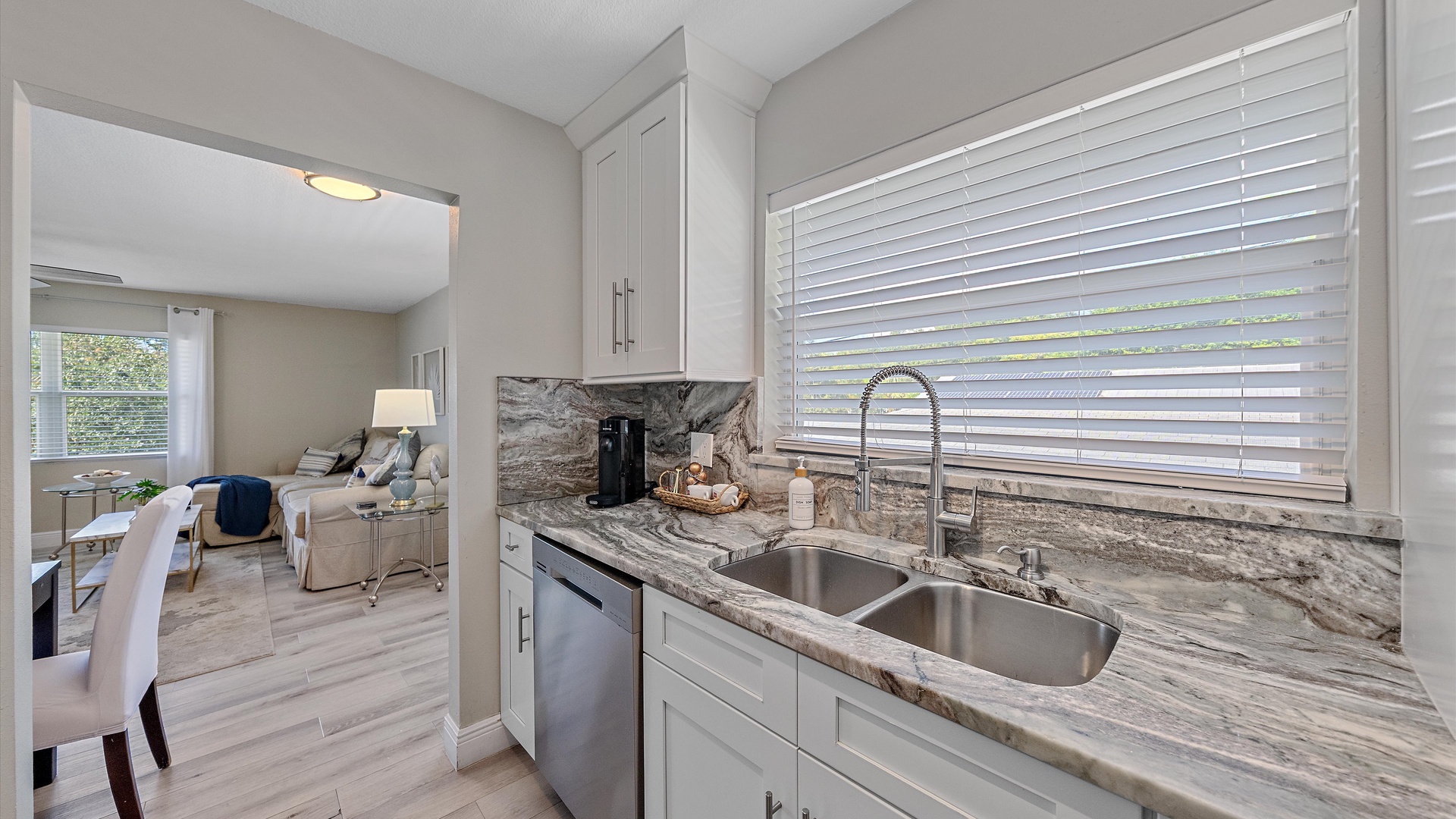 Step into your bright, modern kitchen with gorgeous granite counters and a double sink perfect for meal prep. Gleaming white cabinetry and stylish finishes create a welcoming space for your culinary adventures.