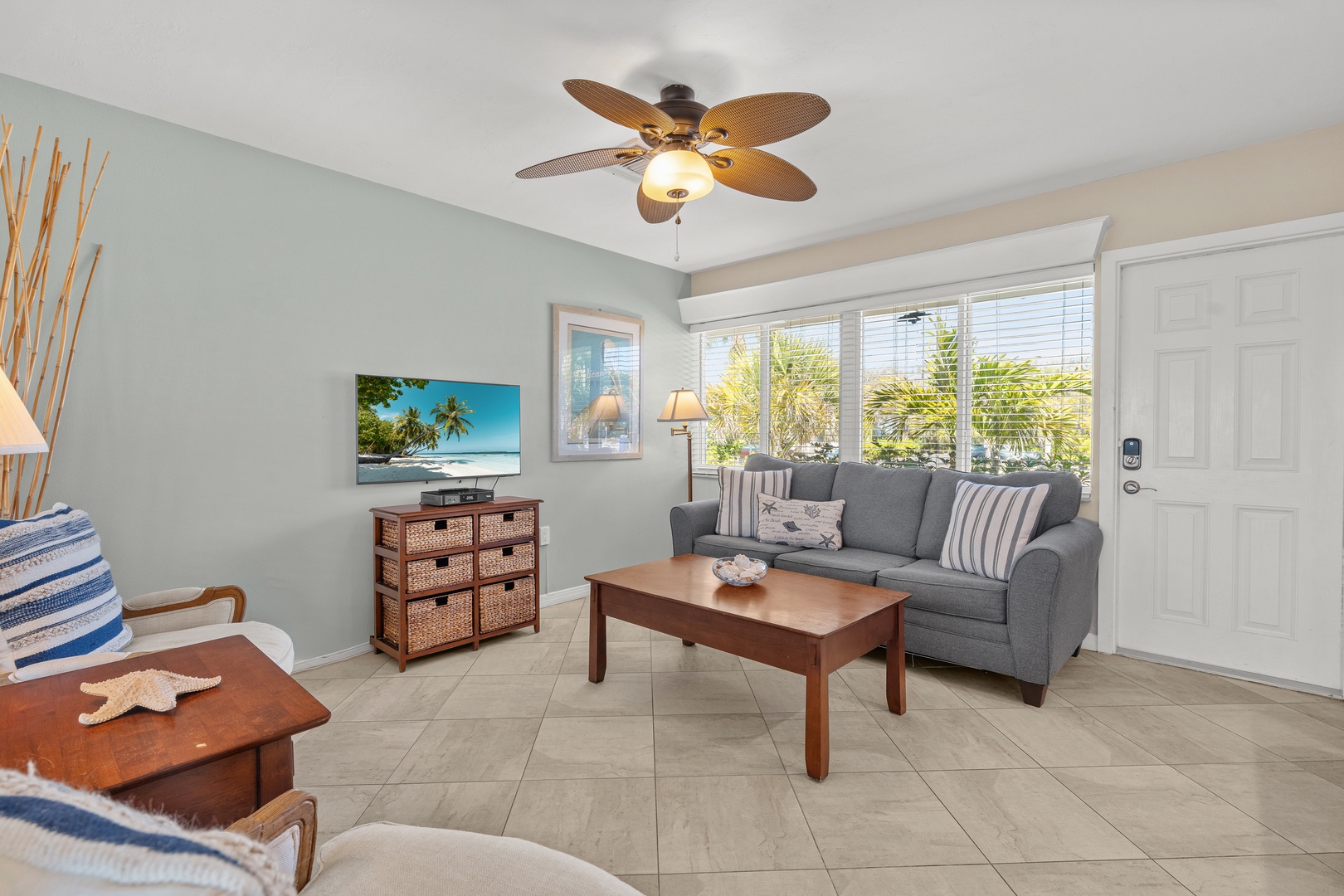 Relax in your bright living room with tropical touches, ceiling fan comfort, and tropical views through your windows.
