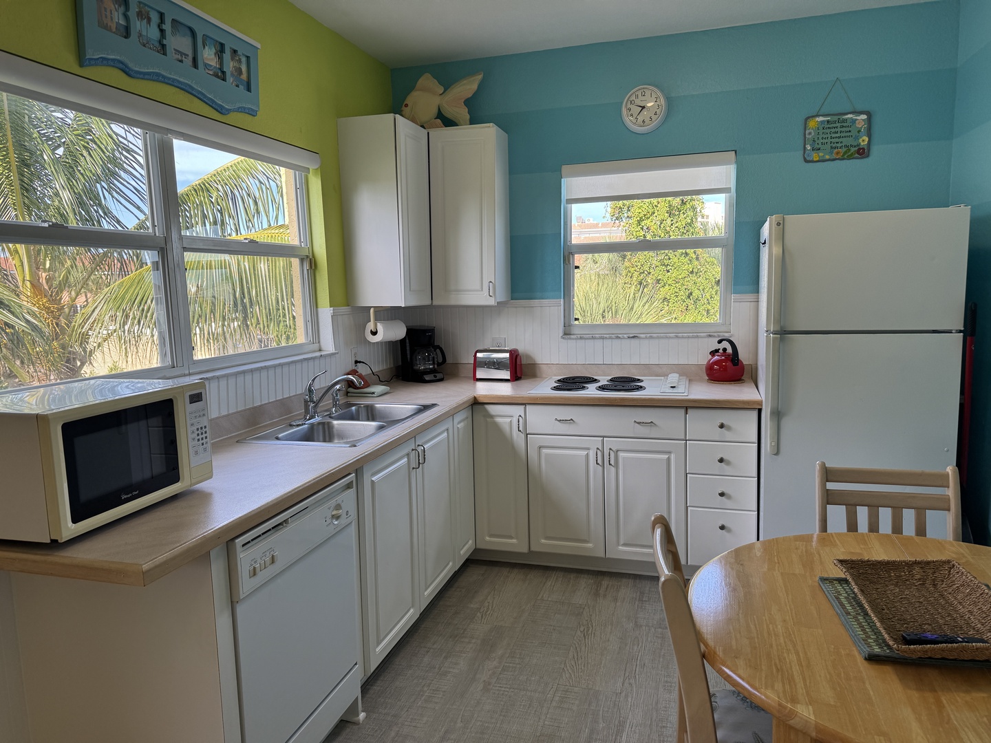 Your fully equipped kitchen with tropical touches invites you to whip up fresh meals while glimpses of palm trees frame the windows, adding that perfect island vibe.