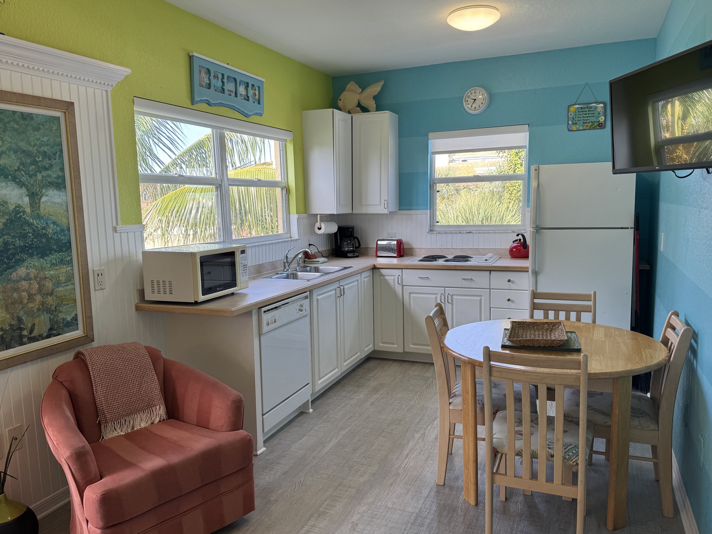 Your bright, coastal kitchen has everything you need, from the microwave and dishwasher to a cozy dining table perfect for morning coffee with views of swaying palms just outside the window.
