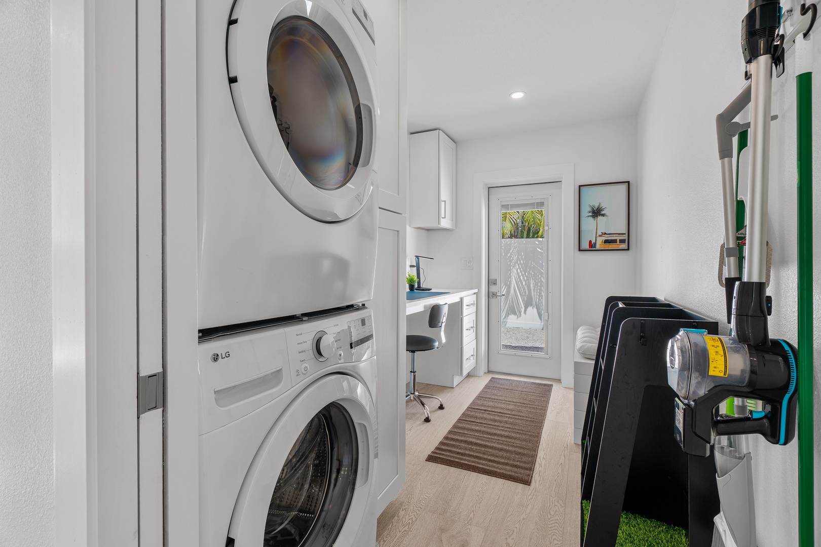 Stackable washer and dryer, sleek storage, and natural light from the patio door make chores effortless.