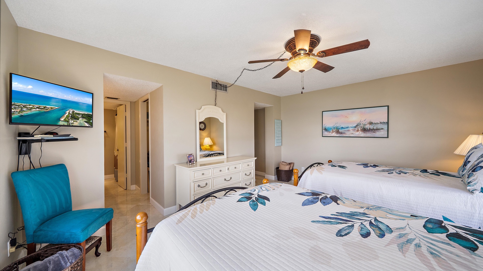 Unwind in your coastal-themed bedroom with twin beds, smart TV, and ocean views on screen for the perfect island getaway.