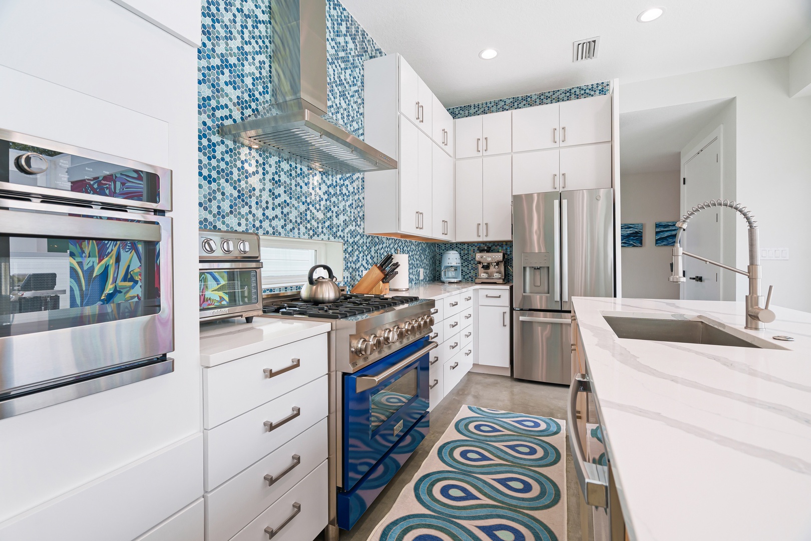 You'll love cooking in this bright modern kitchen with gleaming appliances, ocean-inspired tile accents, and thoughtful details like a chef-worthy gas range. Everything you need is at your fingertips.