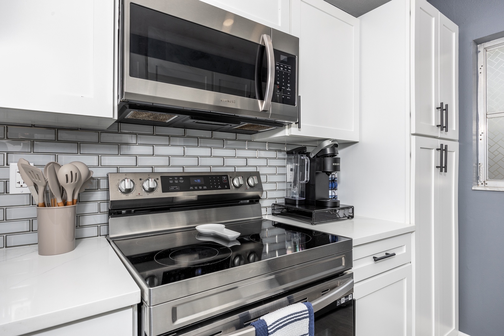Step into your sleek, modern kitchen where crisp white cabinets and gleaming appliances invite you to create memorable meals during your stay.