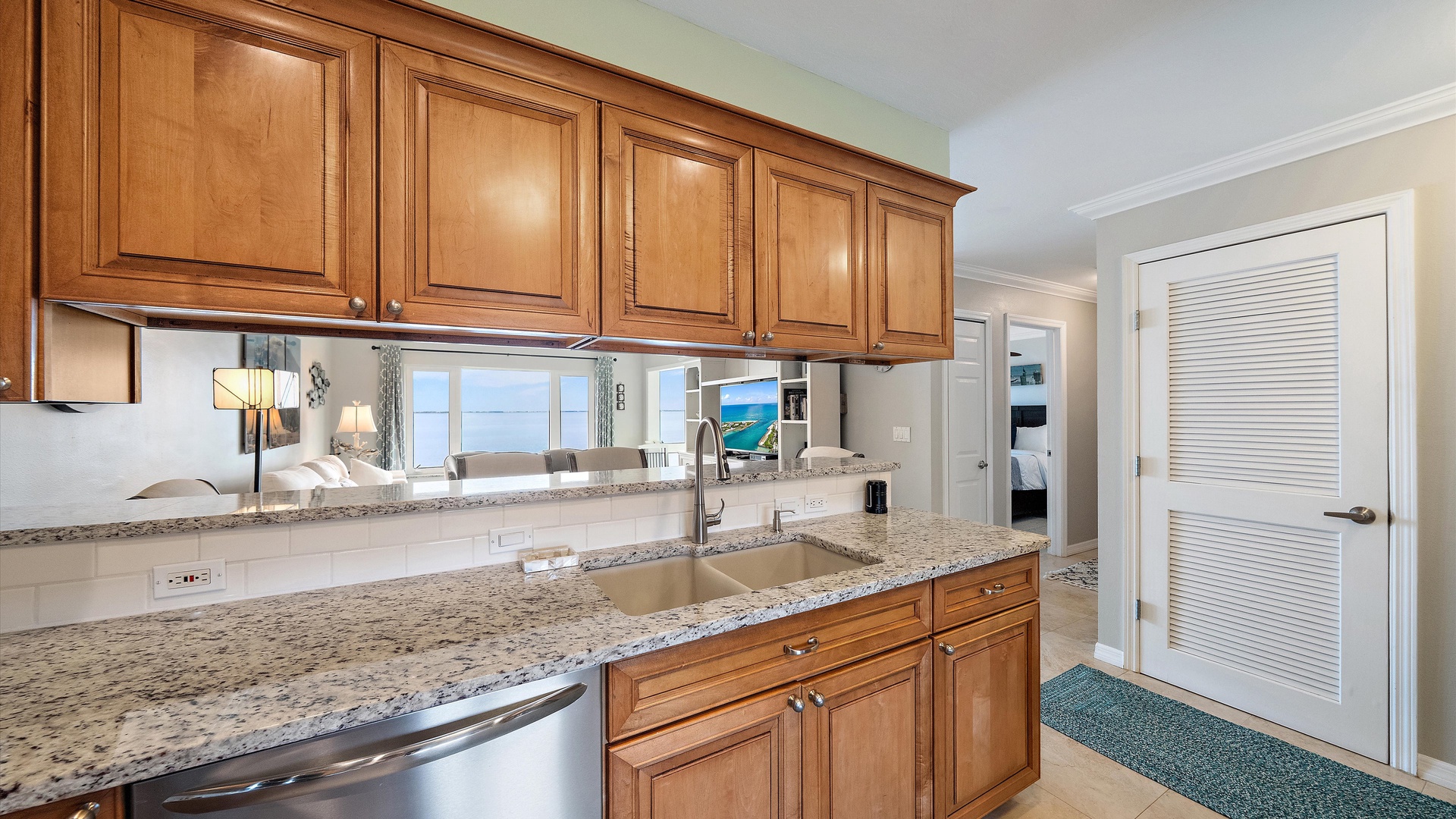 An open pass-through connects the kitchen with the living space beyond. Granite counters and a dishwasher add convenience without closing the kitchen off from the rest of the home.