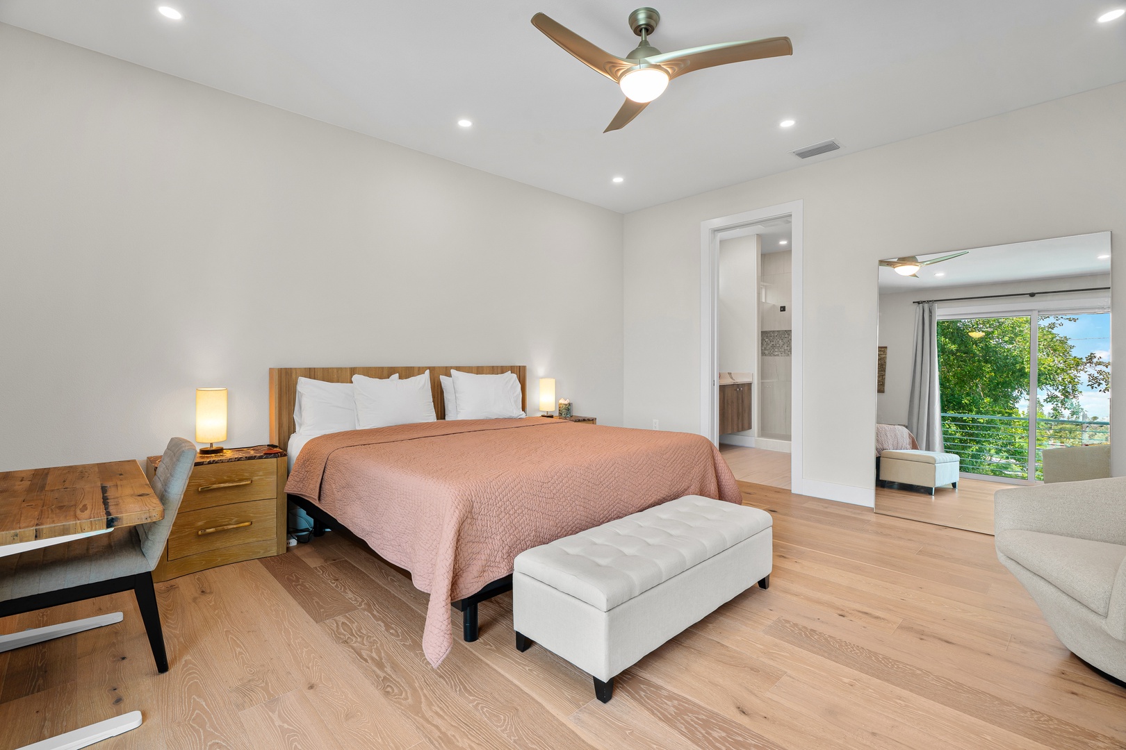 Drift off in your serene bedroom suite, where warm wood tones and crisp linens invite restful nights. Through your private balcony, lush greenery frames your peaceful retreat.