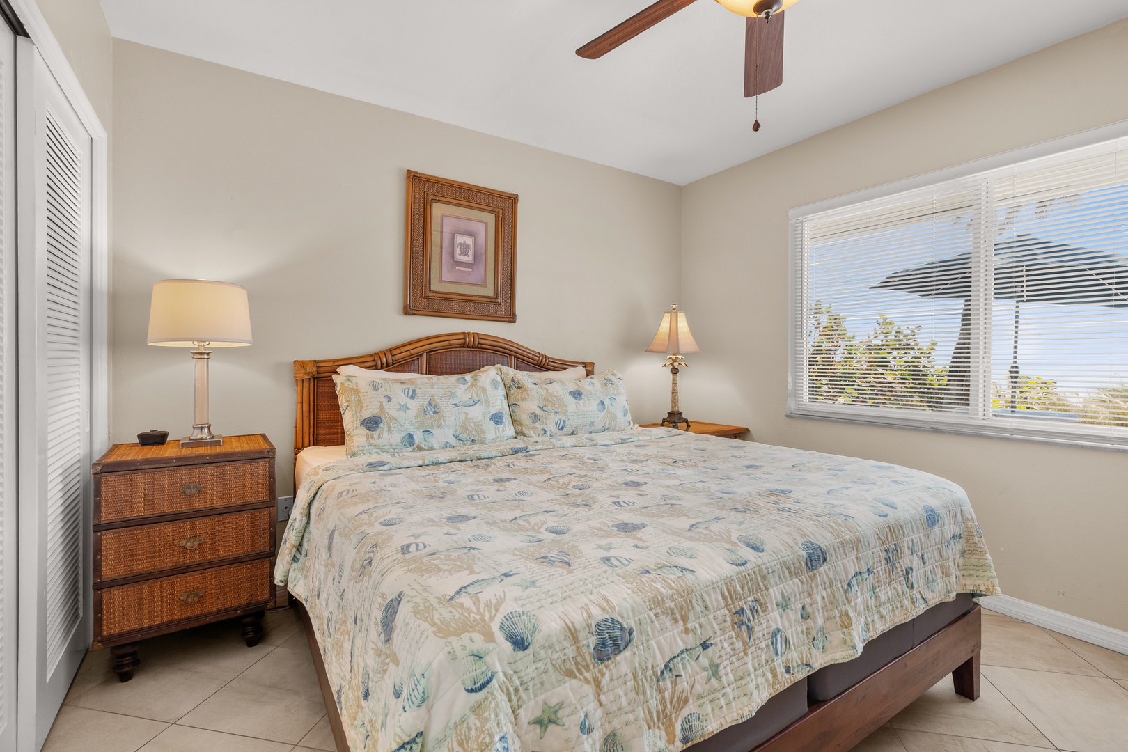 Drift off to sleep in your coastal-themed bedroom with ocean-print bedding, warm wood furnishings, and natural light streaming through.