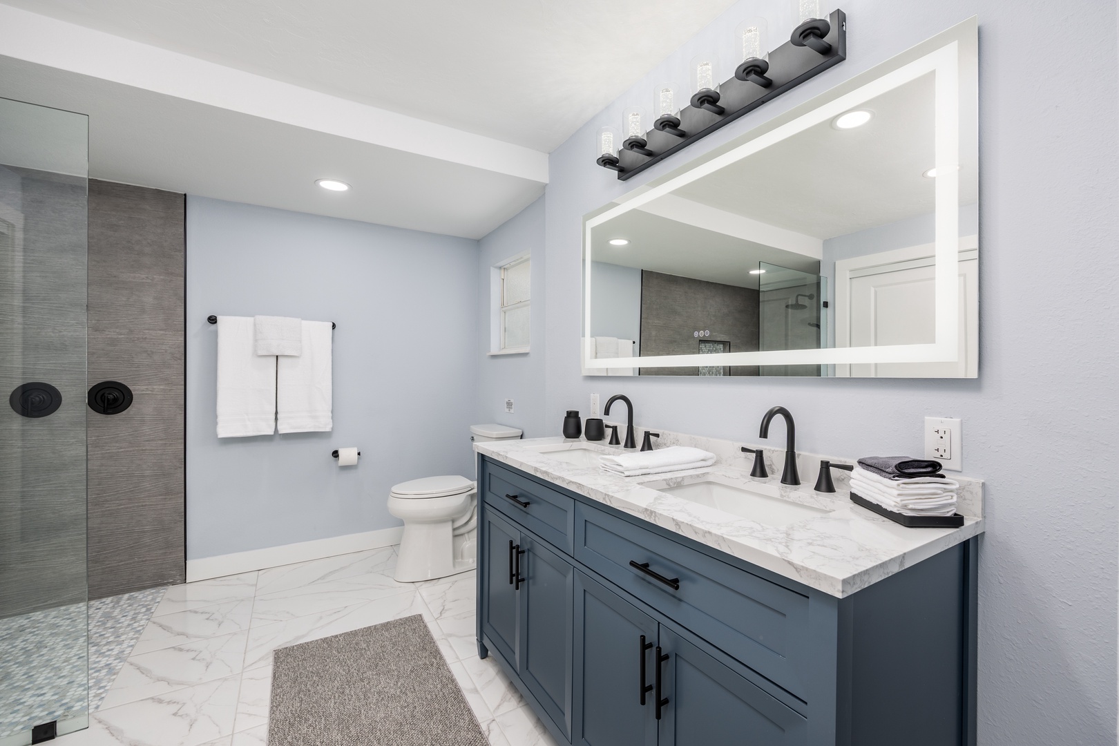 Your spa-like bathroom features dual sinks, a spacious shower, and elegant marble finishes for ultimate relaxation.