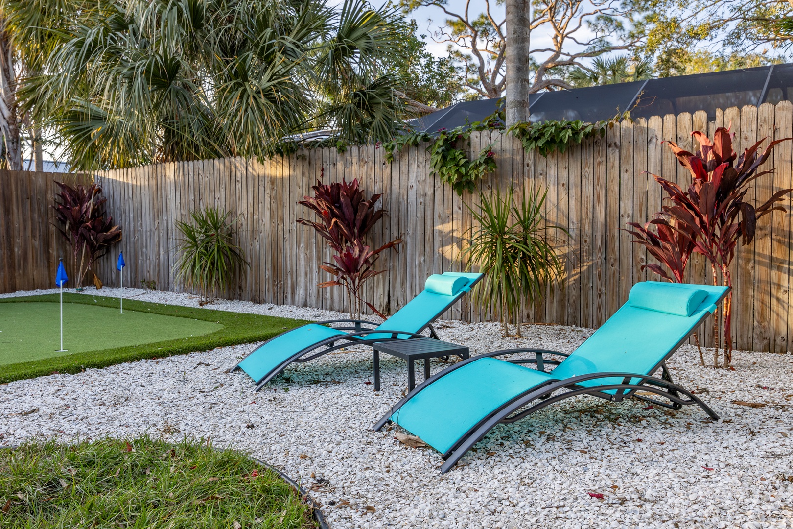 Unwind on turquoise loungers in your private tropical oasis, surrounded by vibrant plants and peaceful garden spaces.