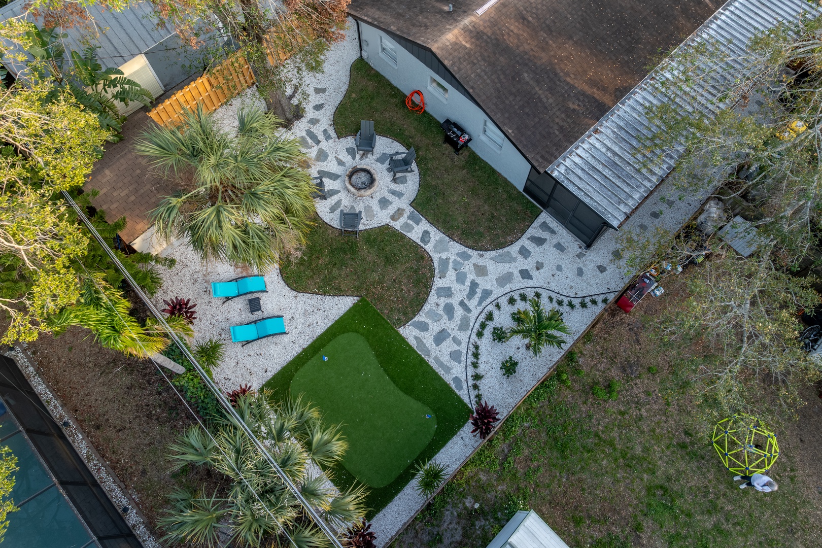 Aerial view showcasing the property's expansive landscaped grounds with tropical gardens, stone pathways, and outdoor recreation areas.