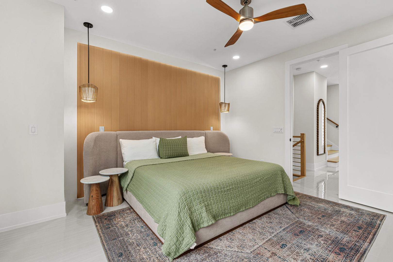 Drift off in this serene bedroom with its cozy king bed, modern wood accent wall, and gentle ceiling fan keeping you perfectly comfortable all night.