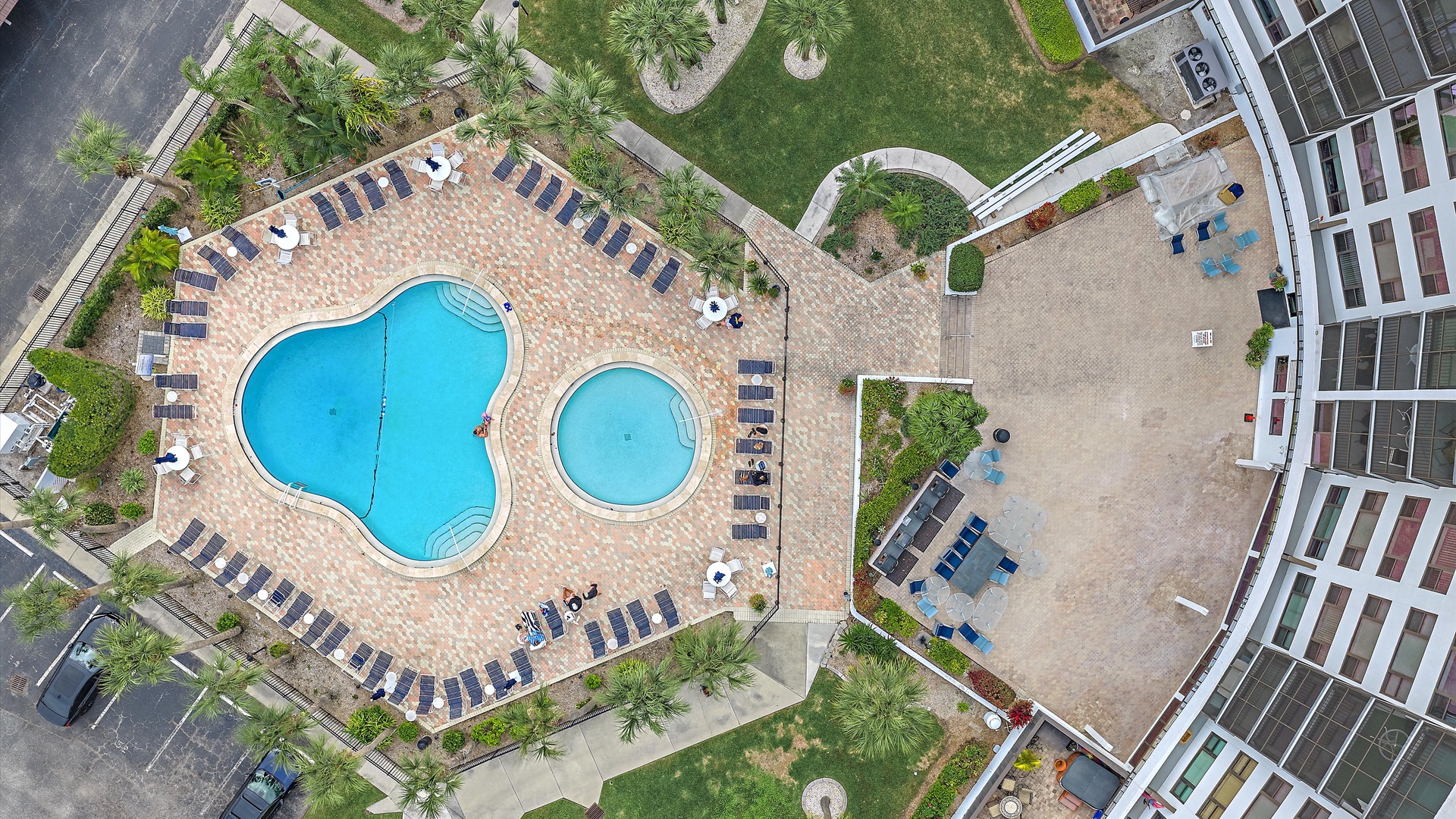 Aerial view of the resort's pool area and surrounding building complex with landscaped grounds.