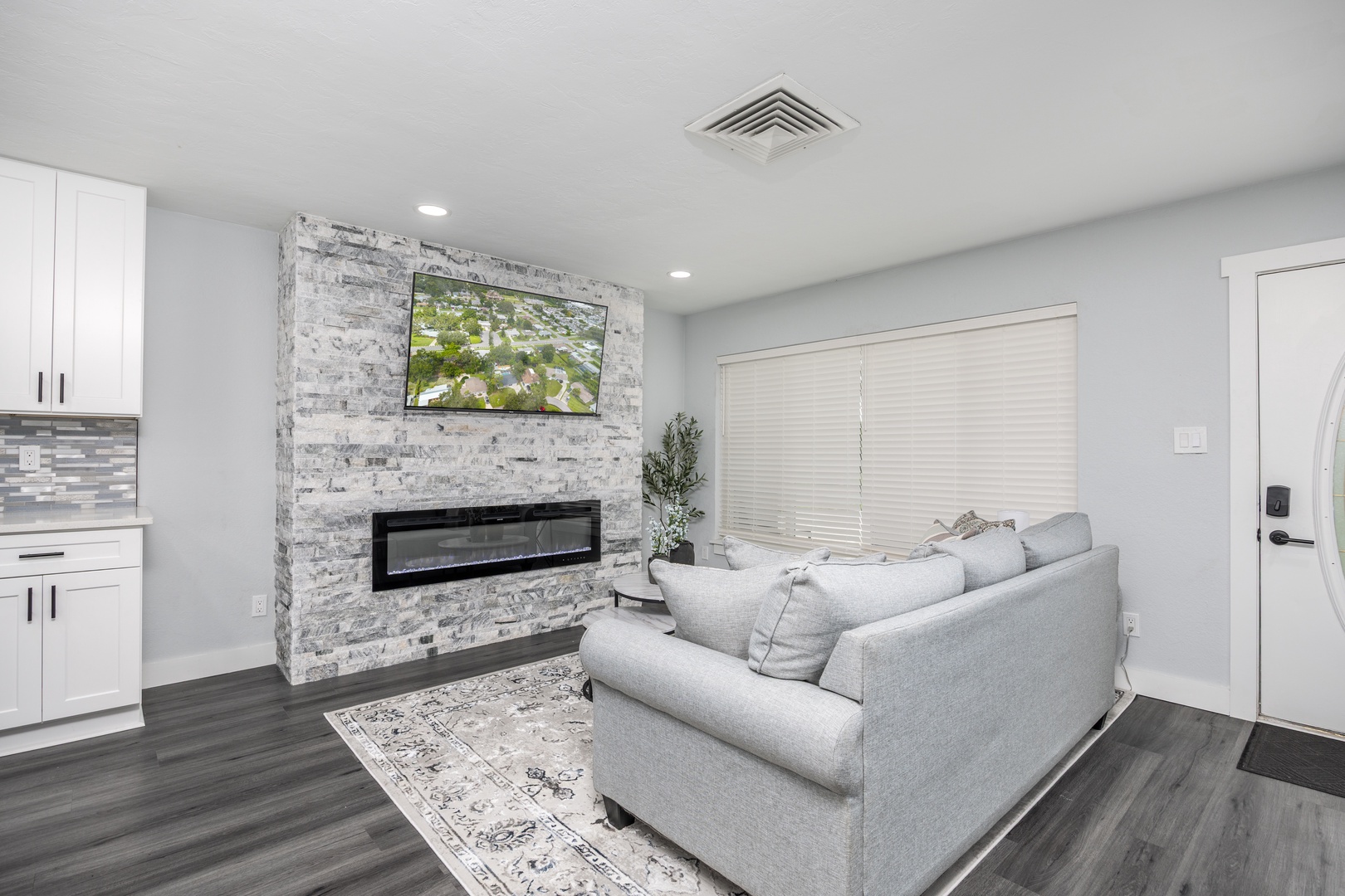 Sink into plush seating by your stone fireplace, where the large TV and cozy ambiance create perfect evenings for relaxation and entertainment.