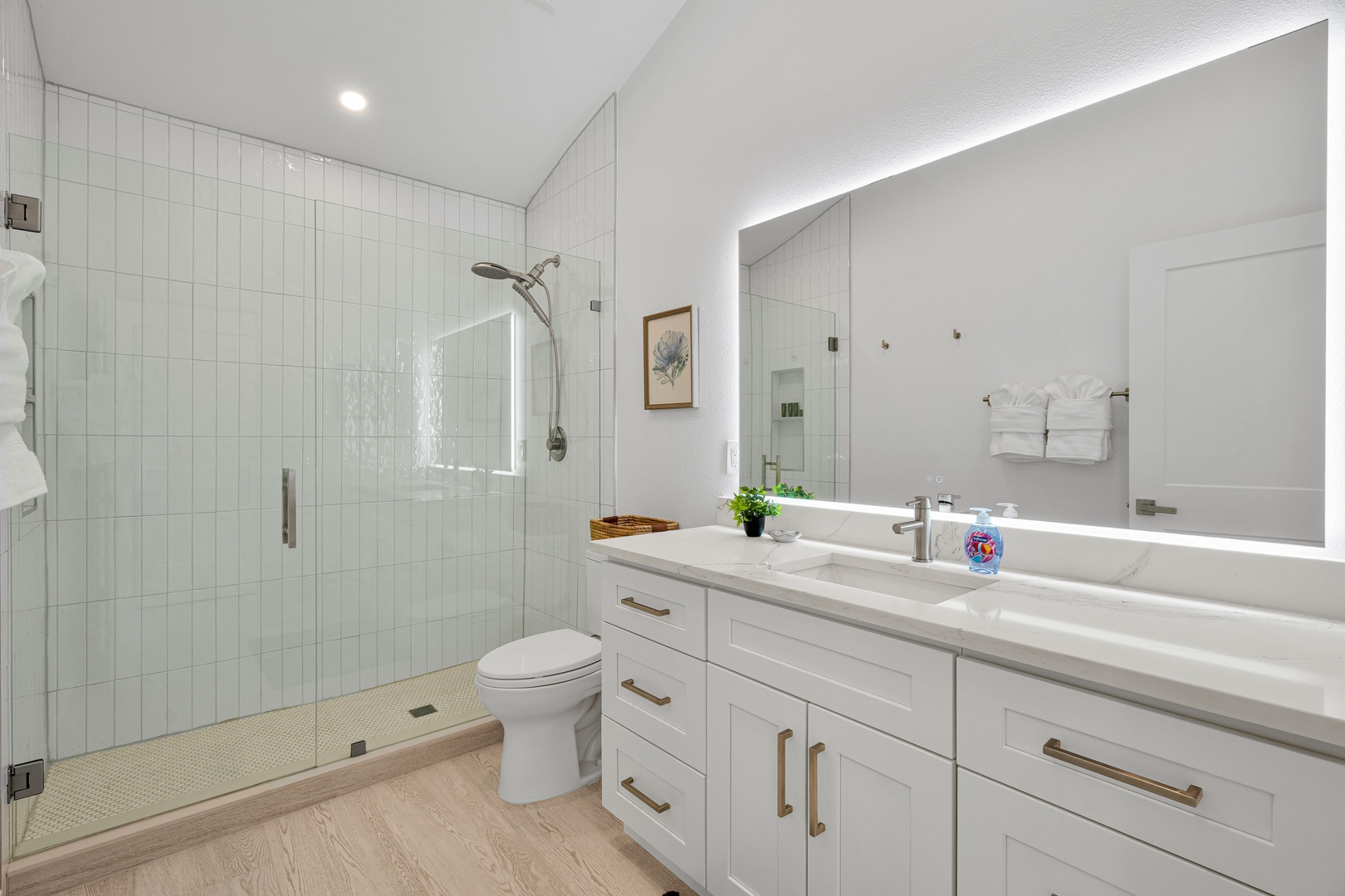 Step into this spa-like bathroom with its walk-in shower, dual vanity, and backlit mirror—your perfect retreat after a day of exploring.
