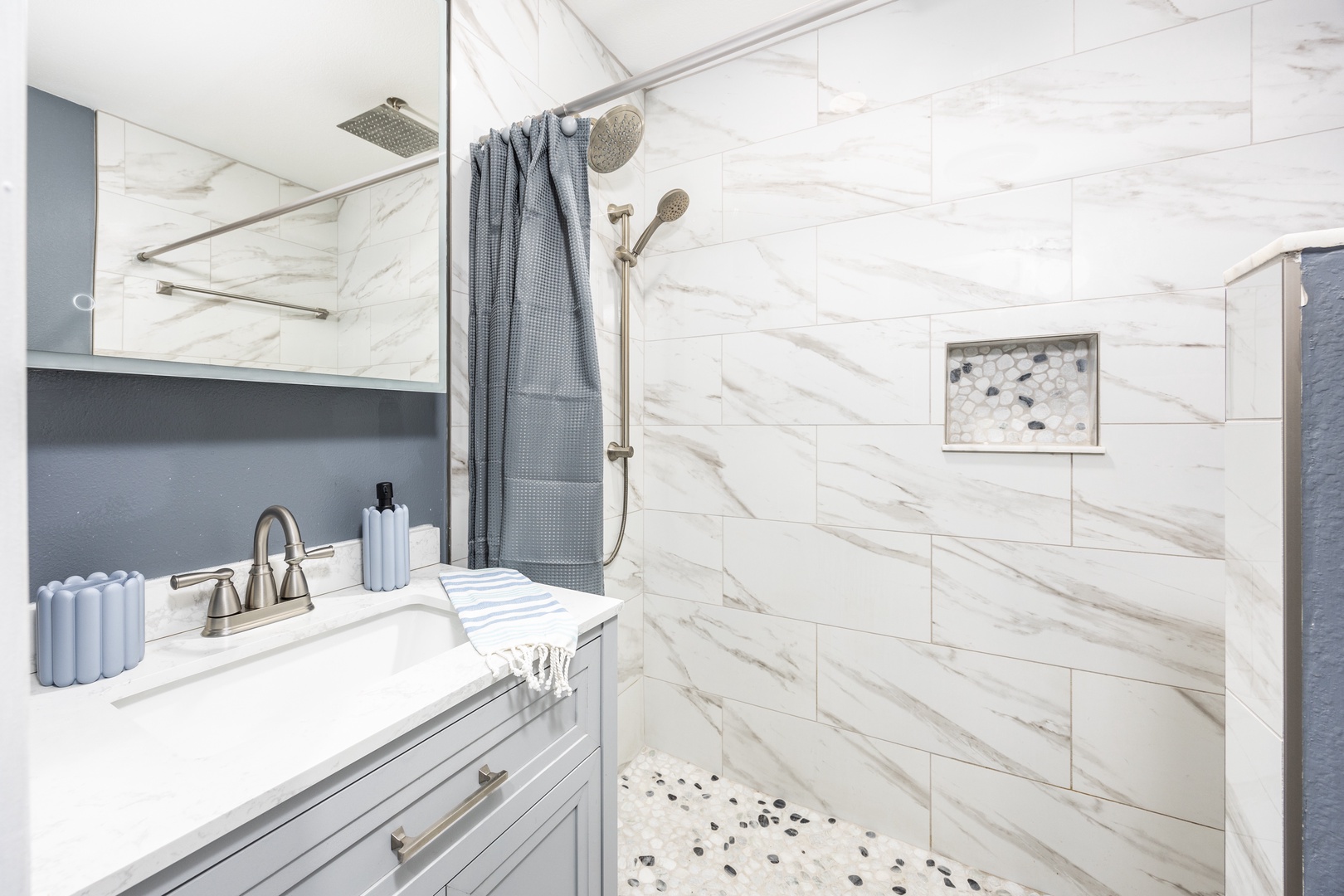 Step into your luxurious marble-tiled bathroom featuring a spacious walk-in shower with dual rainfall and handheld options for the perfect cleansing experience.