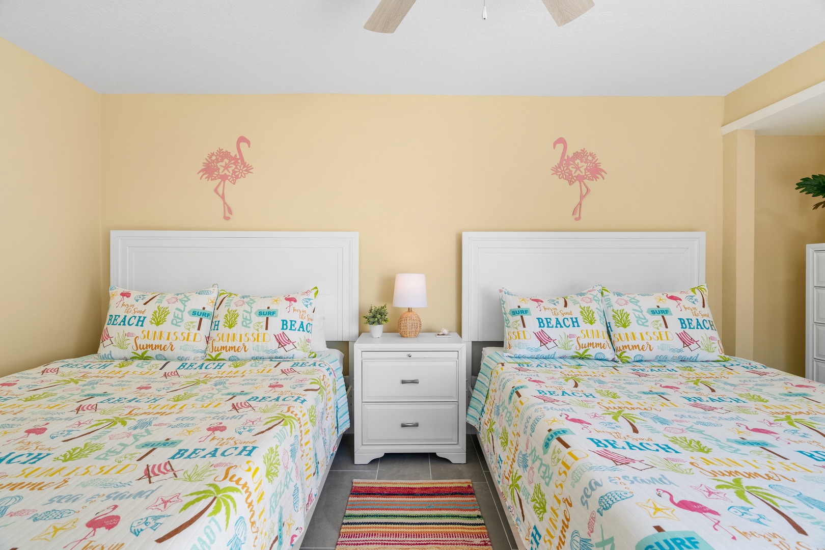 Drift off to sleep in this cheerful twin bedroom with playful beach-themed bedding and tropical flamingo wall art creating a fun coastal vibe.