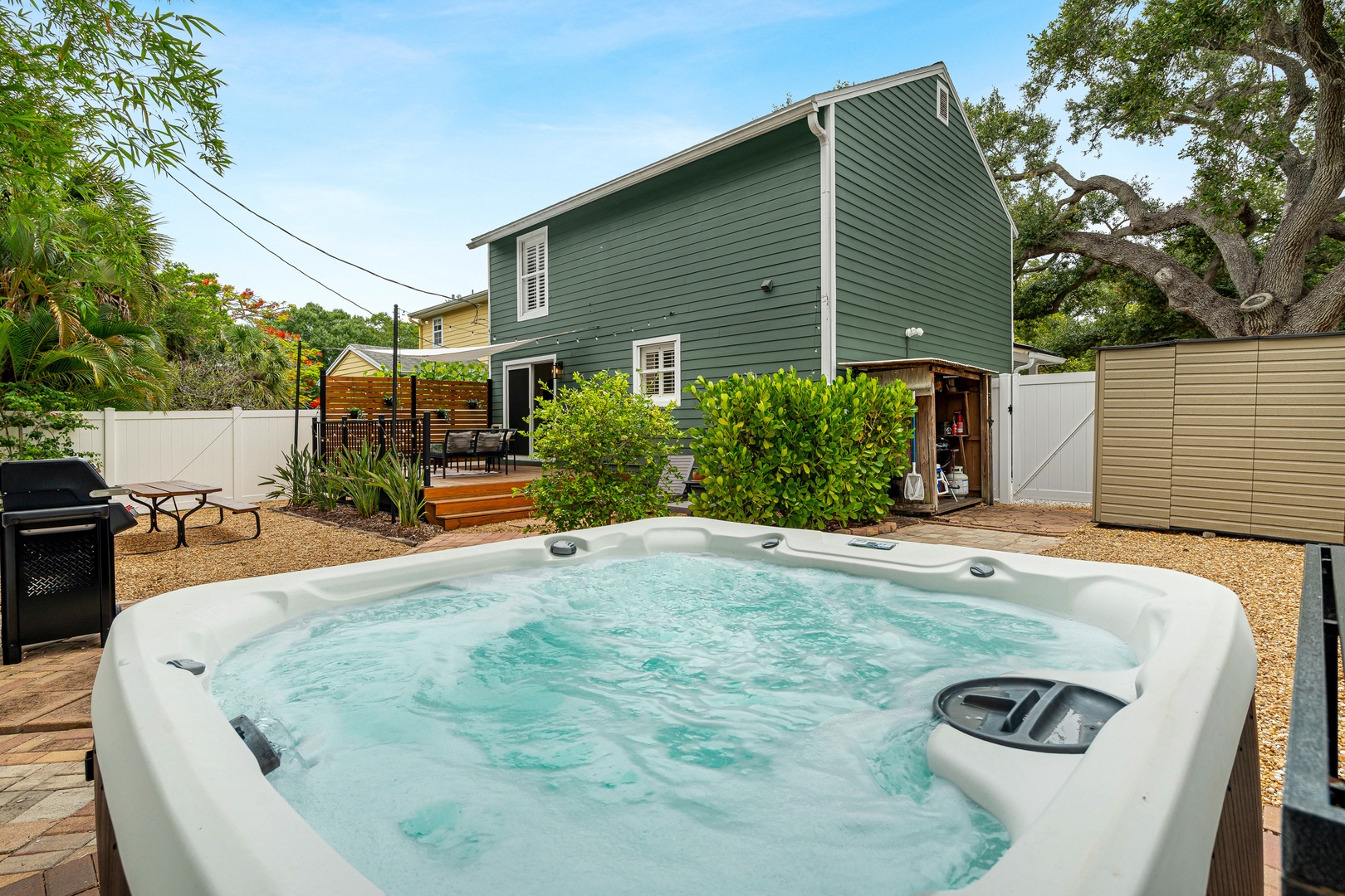 Soak in the bubbling hot tub under open skies, surrounded by lush greenery and peaceful privacy. The spacious backyard offers a grilling area, deck, and plenty of room to unwind outdoors.