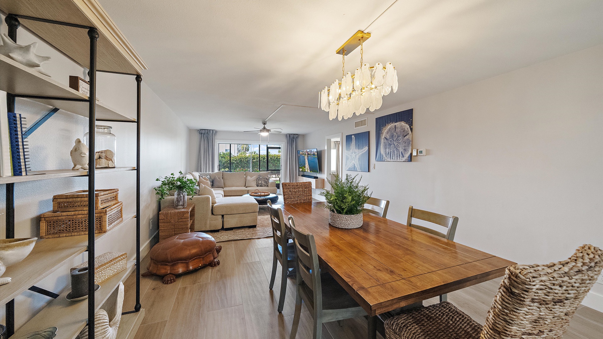 Relax in your open-concept living space where coastal charm meets modern comfort—perfect for gathering around the dining table or unwinding on the plush sofa.