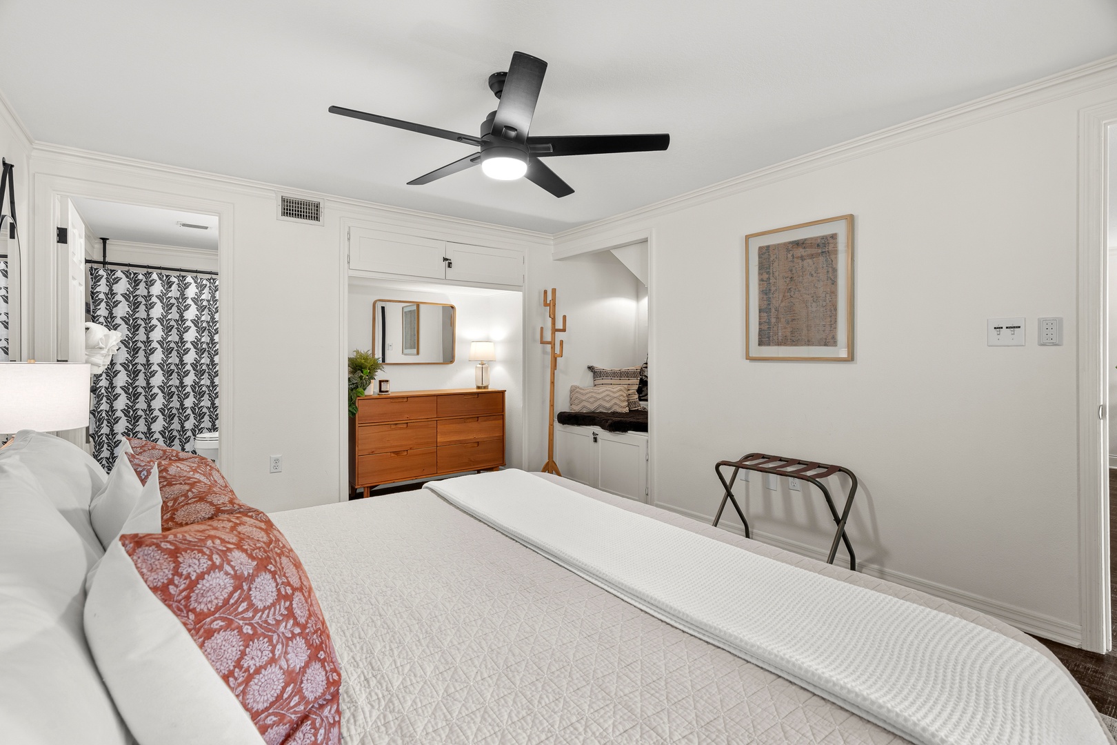 Your serene bedroom retreat features a plush queen bed, mid-century dresser, and modern ceiling fan to keep you cool. Elegant touches and thoughtful furnishings await your arrival.