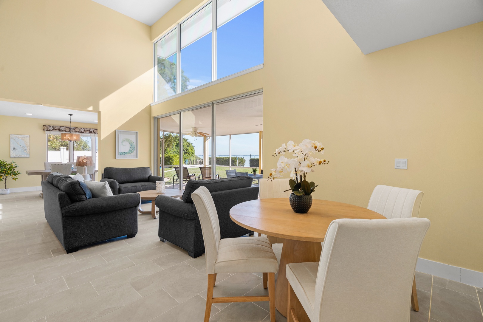 Relax in your spacious living area with soaring ceilings, where natural light floods through floor-to-ceiling windows.
