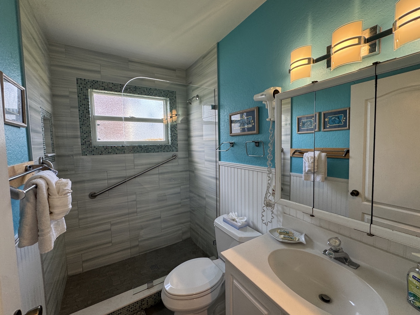 Step into your coastal-inspired bathroom, where calming turquoise walls meet elegant tile work. Enjoy your spacious walk-in shower with stylish mosaic accents and a soothing rainfall experience.