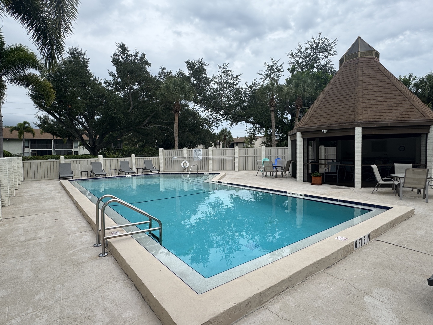 Dive into your own slice of paradise at this sparkling community pool, framed by lush palms and a charming covered cabana perfect for lounging in the shade.