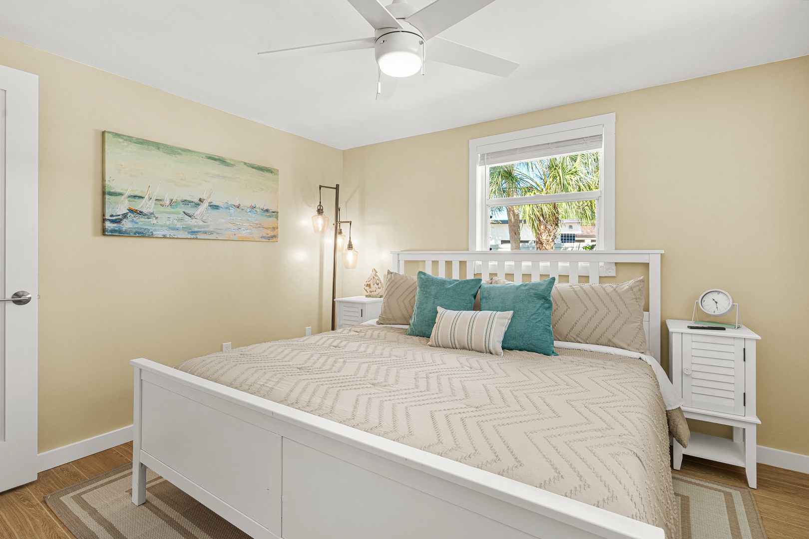 Unwind in your bright, inviting bedroom featuring coastal décor, soft linens, and a gentle ceiling fan. Palm trees sway just outside your window, setting a serene, tropical mood.