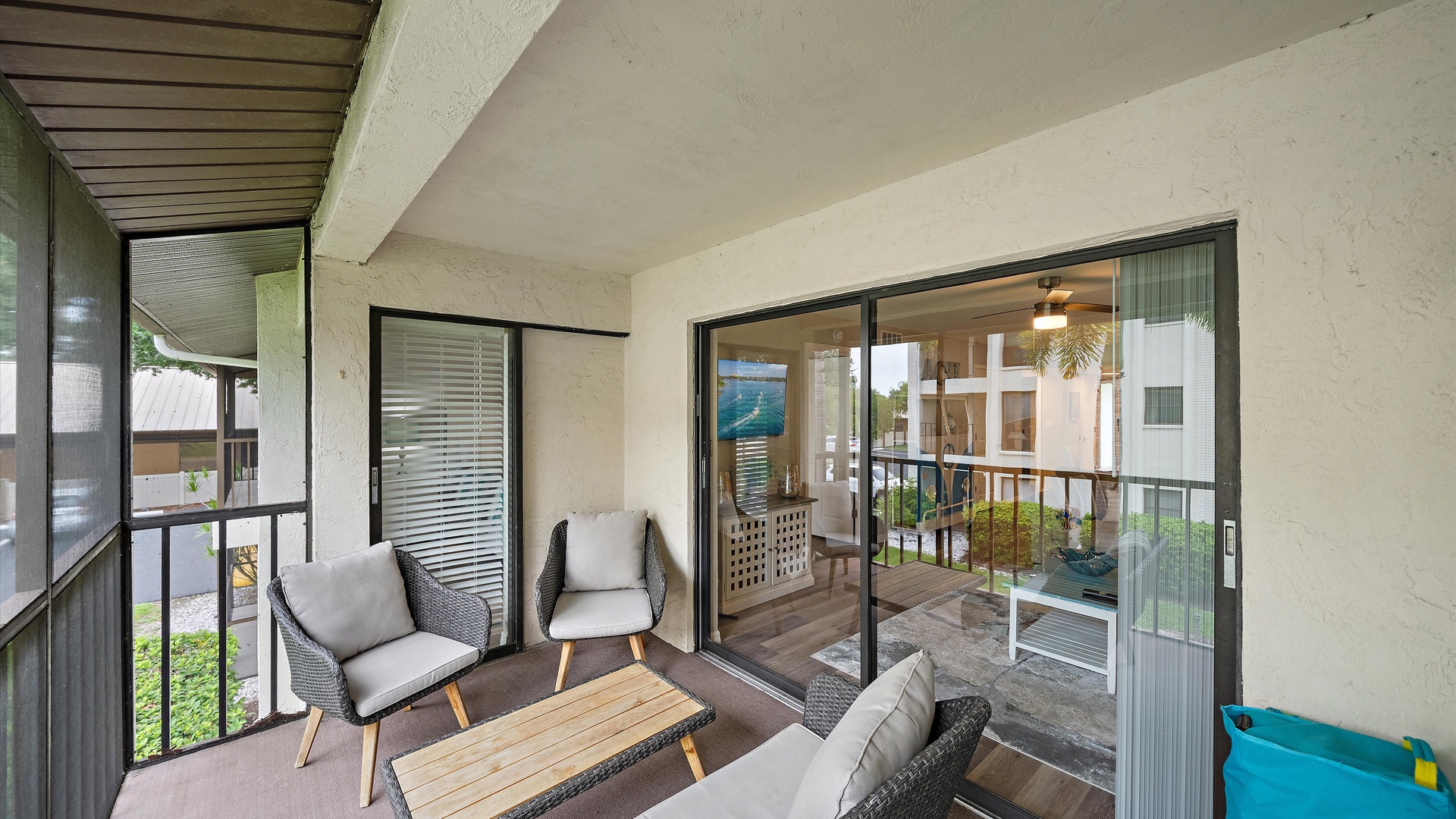 Your private balcony offers a peaceful spot to unwind with comfortable seating and a view into your stylishly appointed living space. Natural light flows through the glass doors, creating a welcoming indoor-outdoor connection.