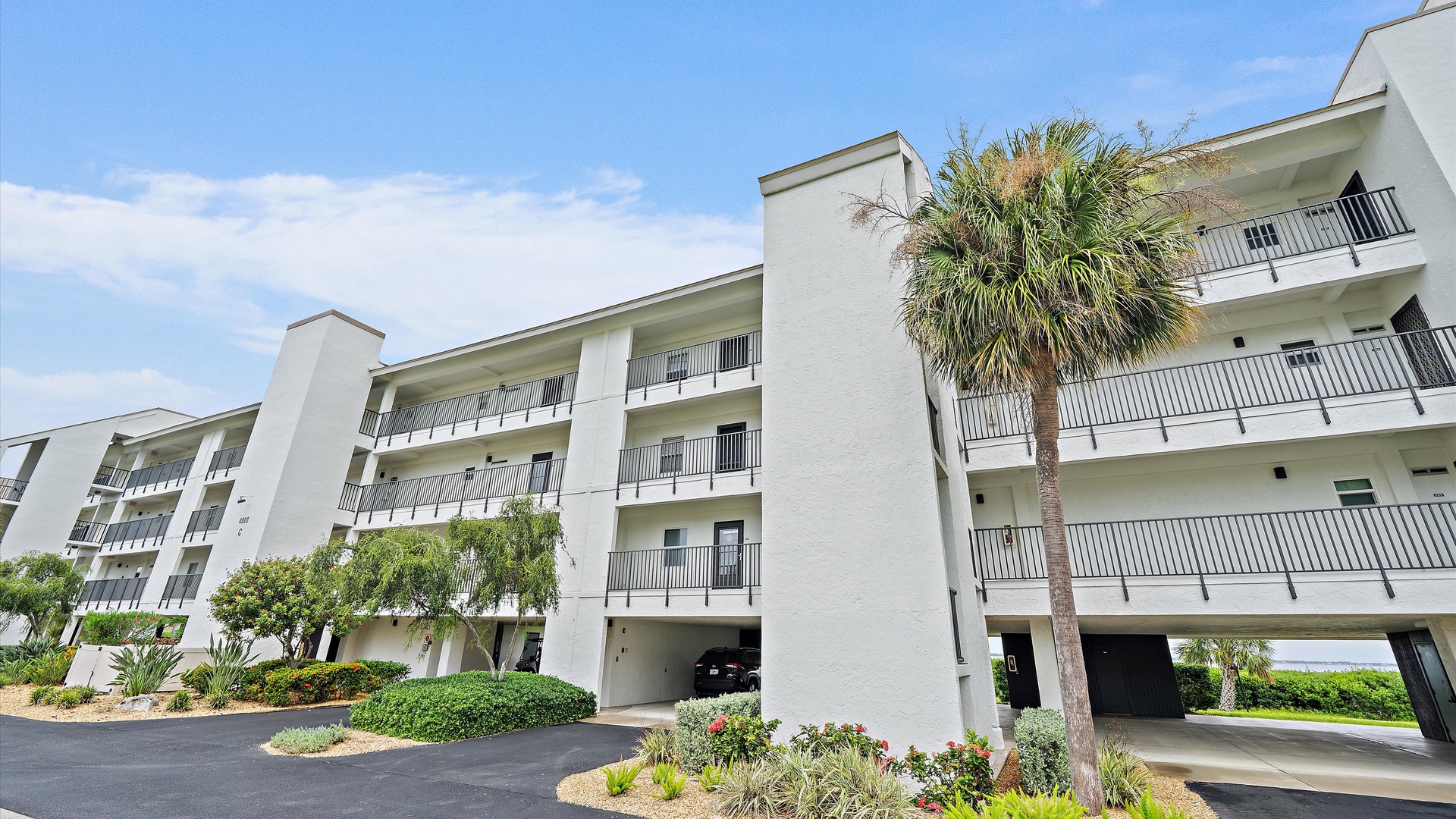 Palm-lined grounds and covered parking frame the building’s exterior. Windward Bay combines a relaxed coastal setting with the everyday convenience of a residential condominium community.