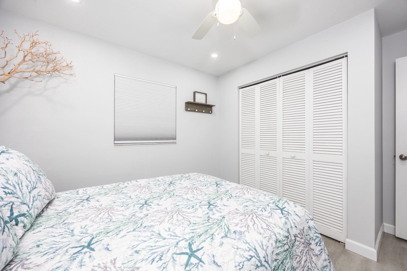 Drift off to sleep in your serene coastal-themed bedroom, where soft coral linens and gentle ceiling fan breezes create the perfect retreat.