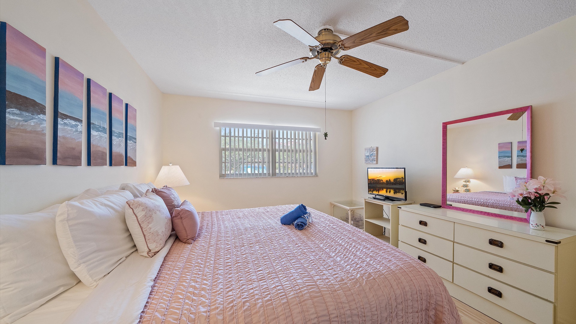 Soft sunset tones and plush bedding welcome you to this tranquil bedroom, where ceiling fan comfort meets coastal charm. Your mirror and TV setup make this space both relaxing and convenient.