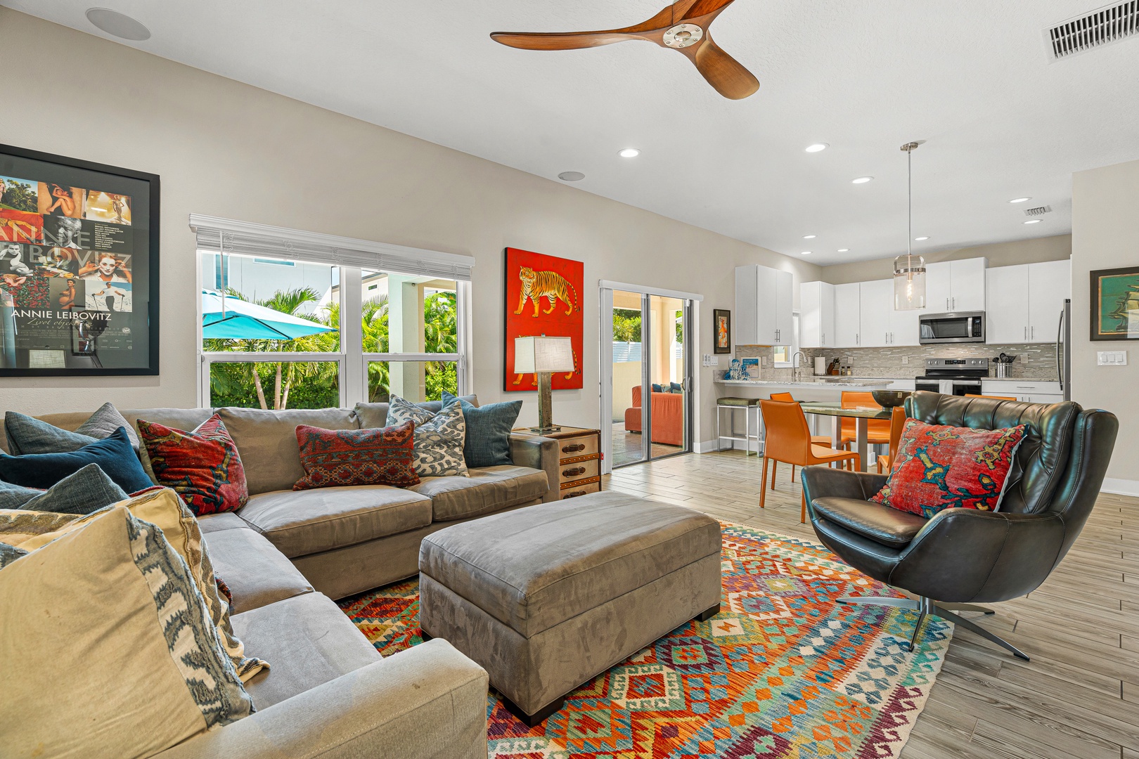 Picture yourself relaxing in this vibrant open-plan retreat, where mid-century style meets tropical ease. Sink into plush seating as the ceiling fan keeps you cool, then step through French doors to your private outdoor oasis.