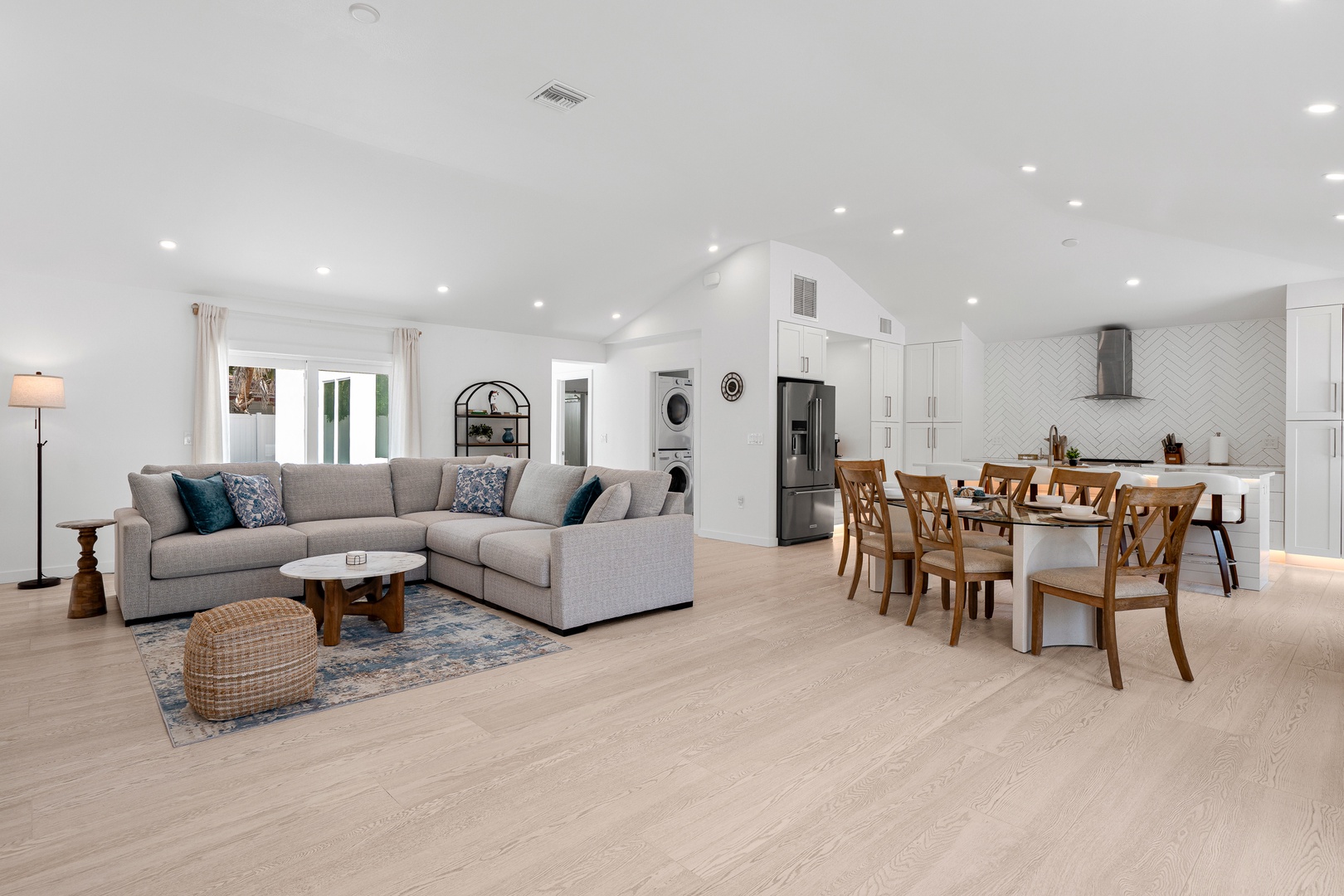 Sink into the plush sectional or gather at the dining table in this bright open-concept space. Sunlight, modern finishes, and a chef-ready kitchen make every moment feel effortlessly comfortable.
