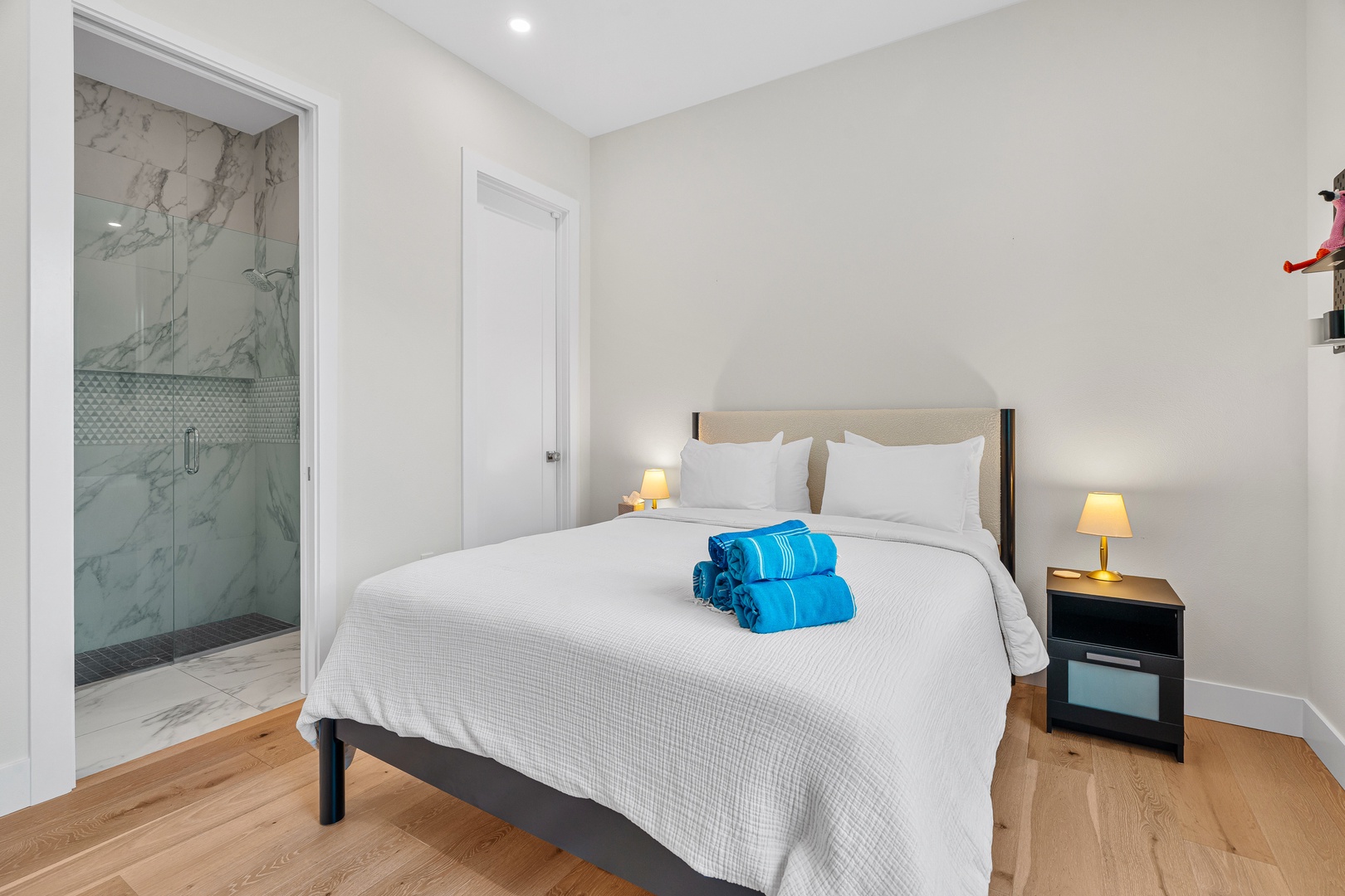 Sink into crisp linens in your serene bedroom, where soft lighting and warm wood floors create a peaceful retreat. Your private ensuite features a luxurious marble shower waiting for you.