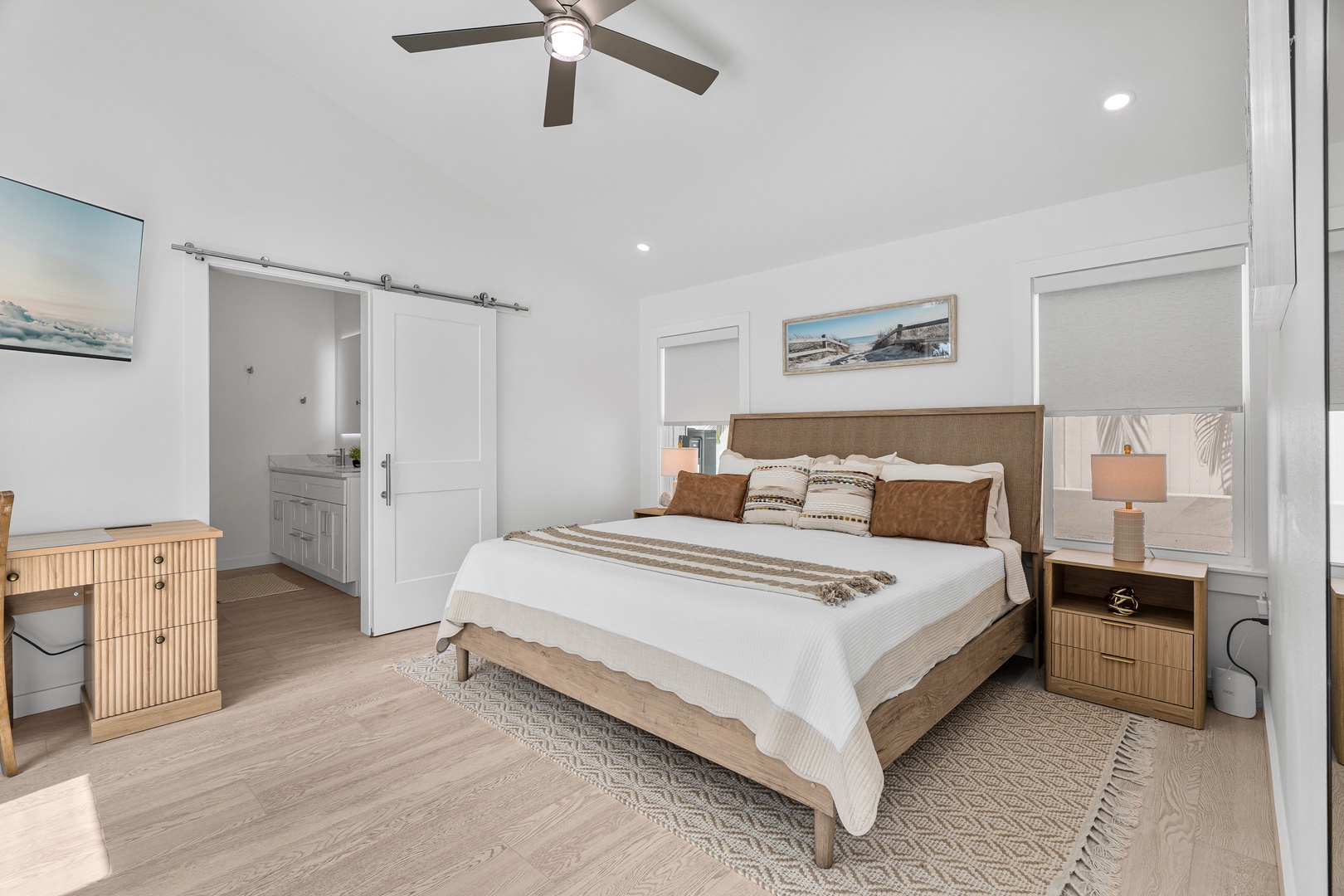 Your serene bedroom retreat features coastal charm with soft linens, warm wood tones, and a gentle ceiling fan to lull you into restful sleep after sun-filled days.