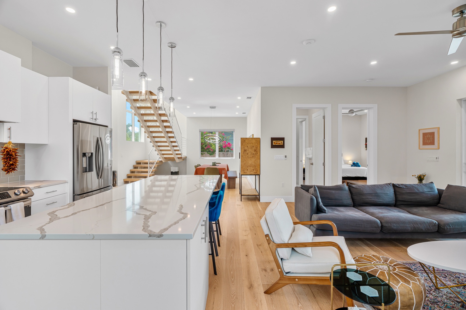 Bright, airy space where your vacation unfolds—marble counters gleam, stairs lead to private retreats, and relaxation beckons from the plush sofa.