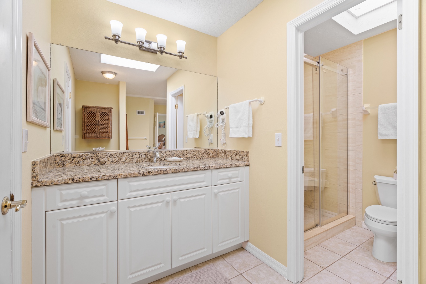 Your spacious bathroom features a double vanity with granite countertops, elegant lighting, and a walk-in shower—perfect for your morning routine.