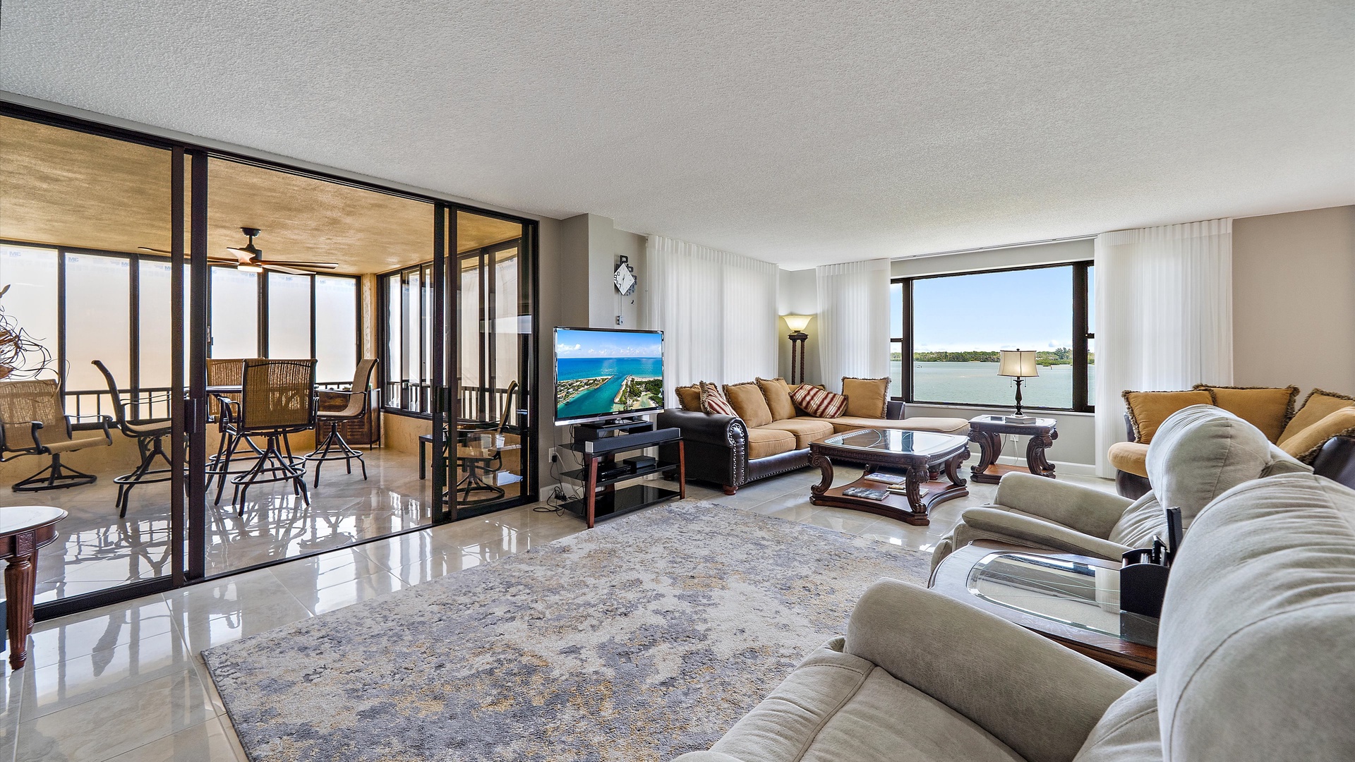 Unwind in your spacious living room with floor-to-ceiling windows, plush seating, and stunning balcony views that create the perfect retreat.
